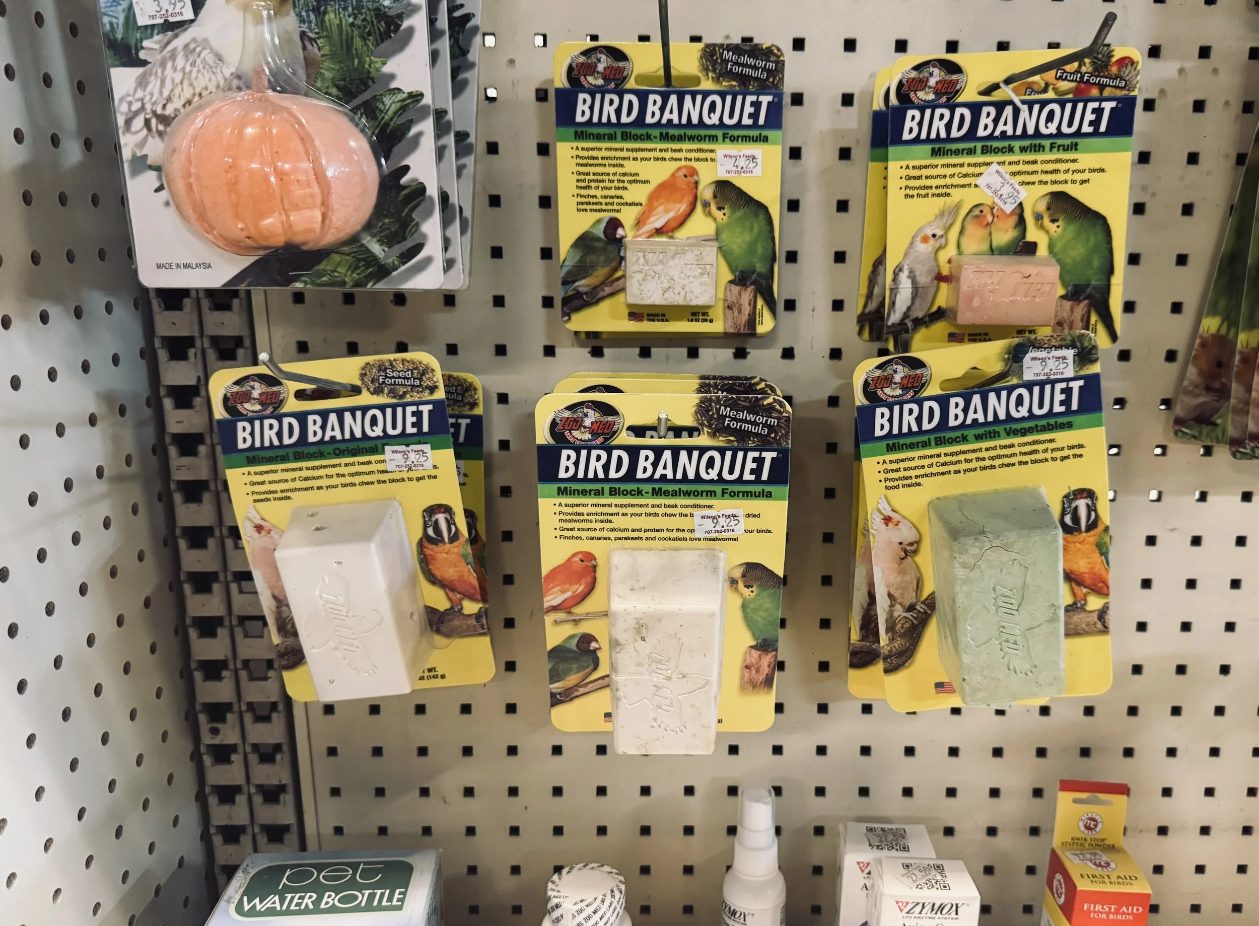 Bird ornaments and seed block packages labeled 'Bird Banquet' on a store display shelf.