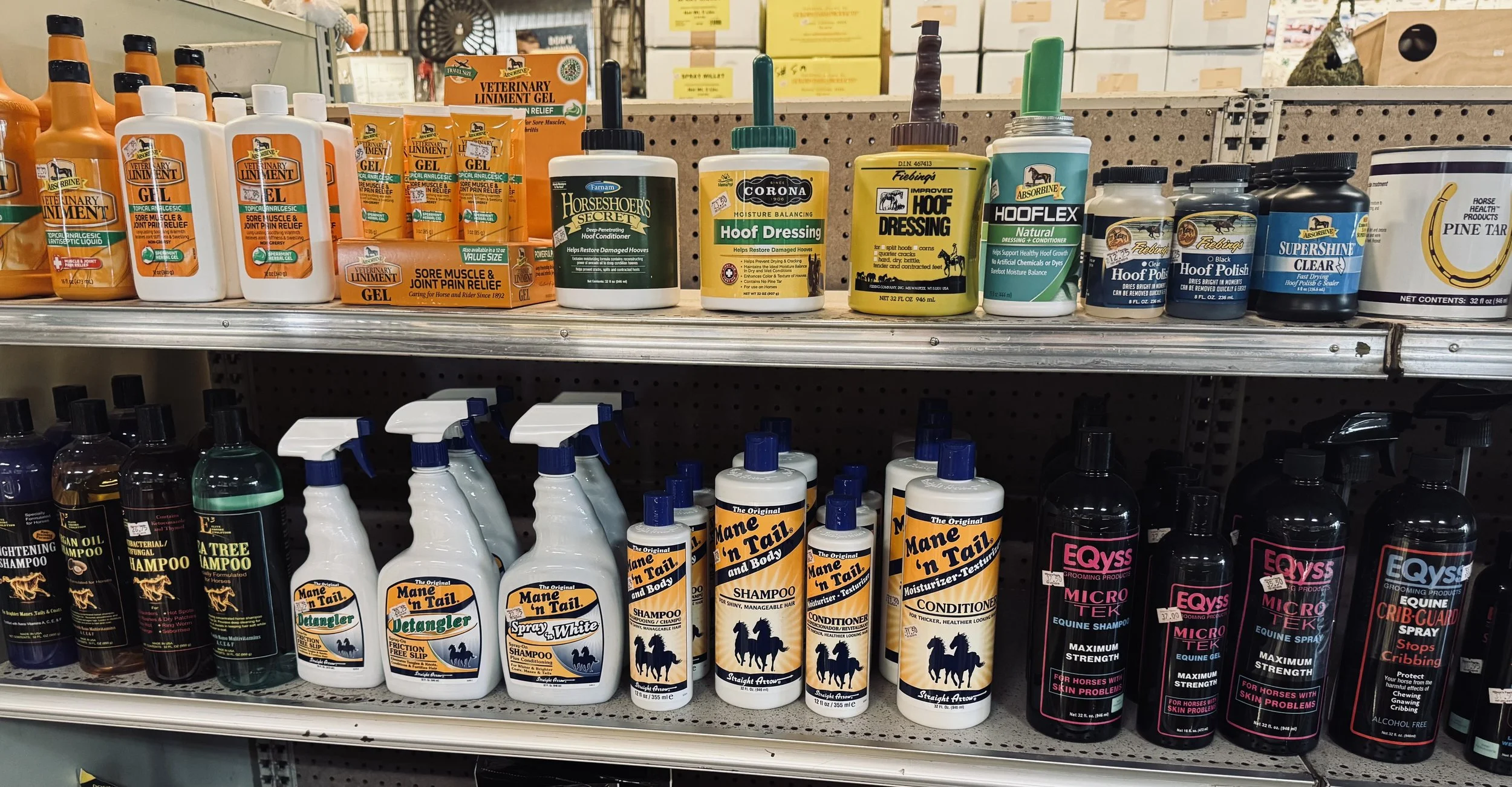 Store shelf displaying horse care products including veterinary liniment gel, hoof dressing, hoof flex, and equine grooming sprays.