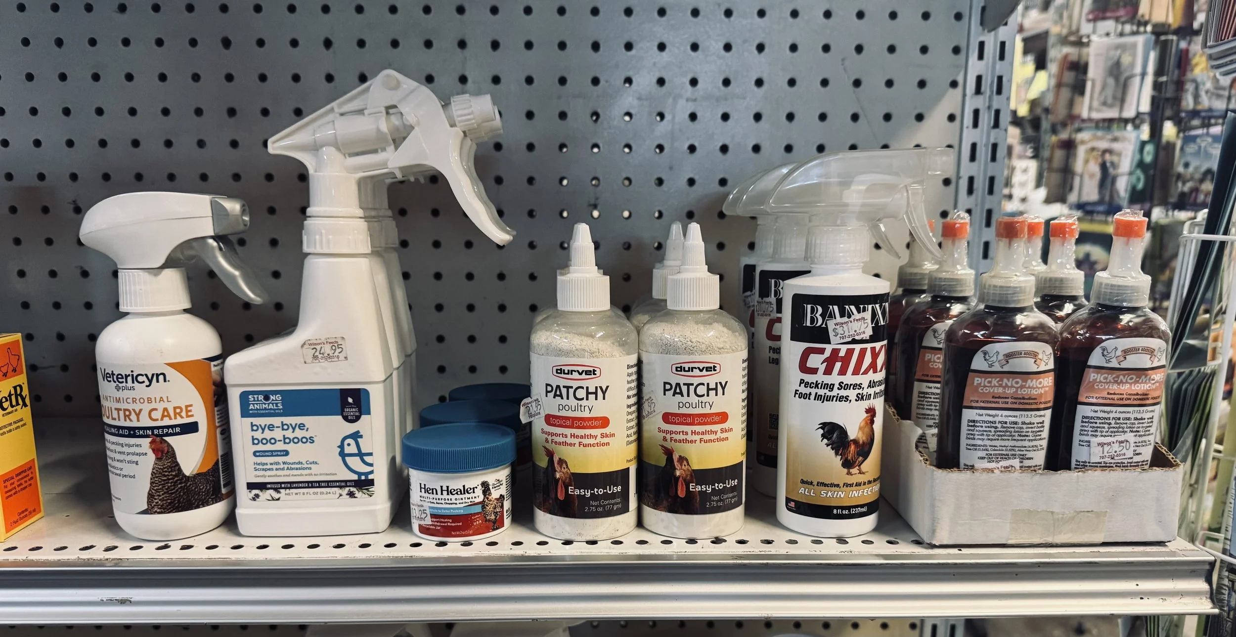 Shelves displaying bottles of various pet care products, including sprays and powders for animals.
