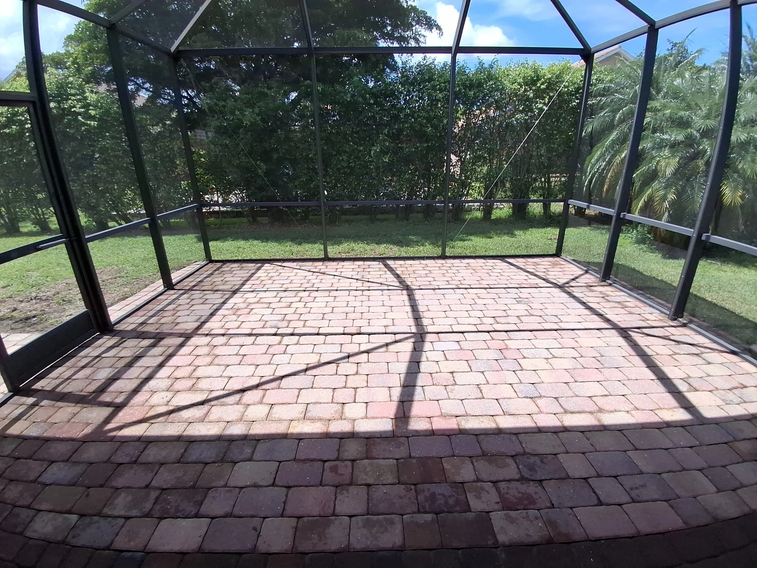 Clean brick pavers in a screened lanai after CBX pressure washing