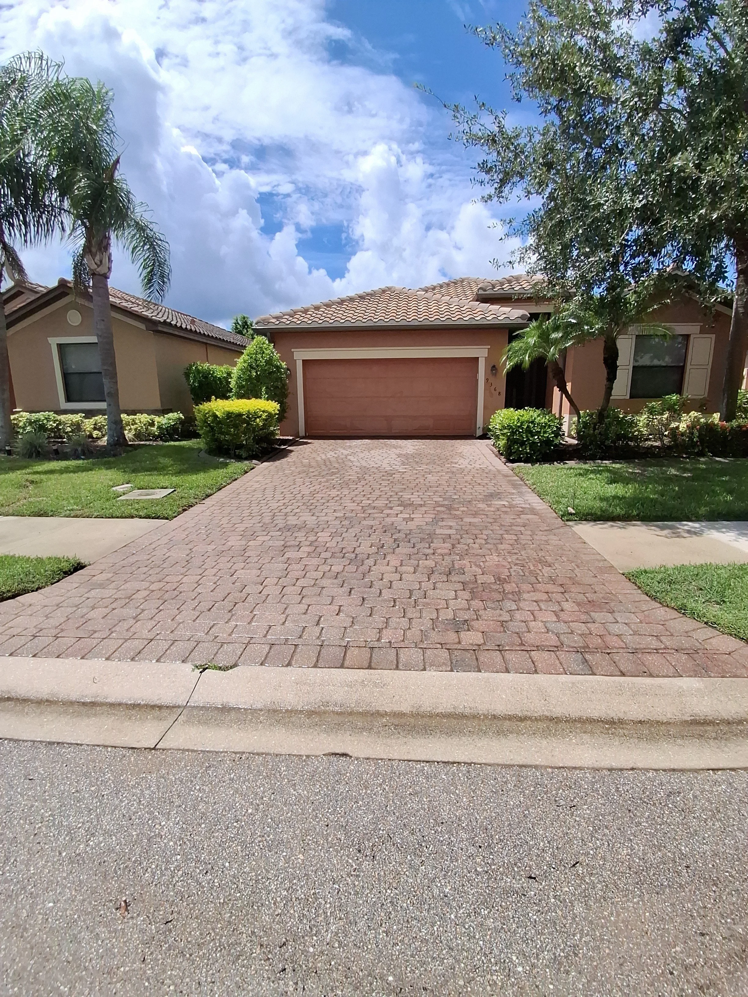 Clean paver driveway and home exterior after CBX pressure washing
