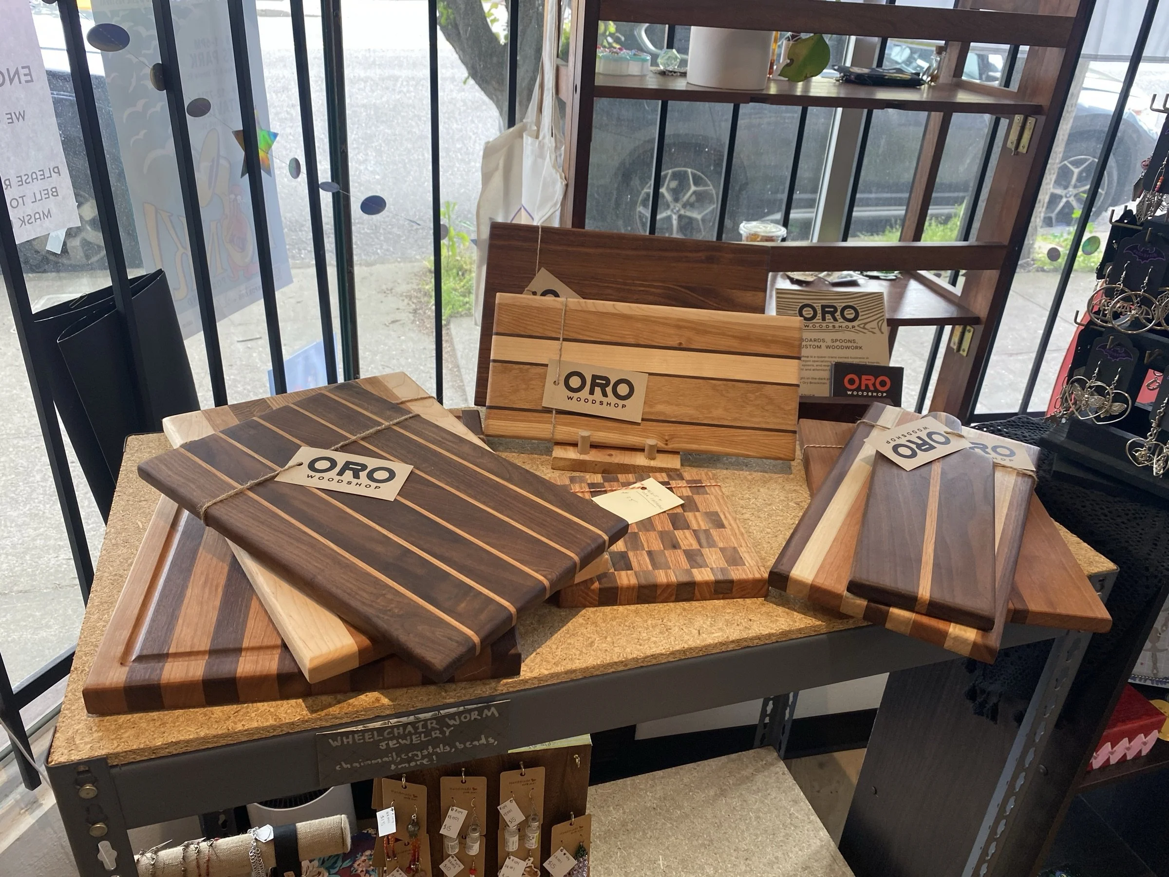 Cutting boards arranged on a cork-topped table at a market.