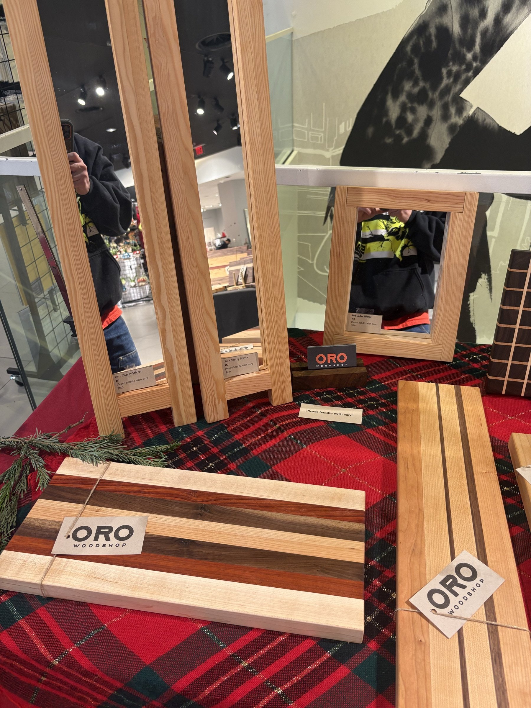 An Oro Woodshop craft-fair booth with cutting boards and mirrors.