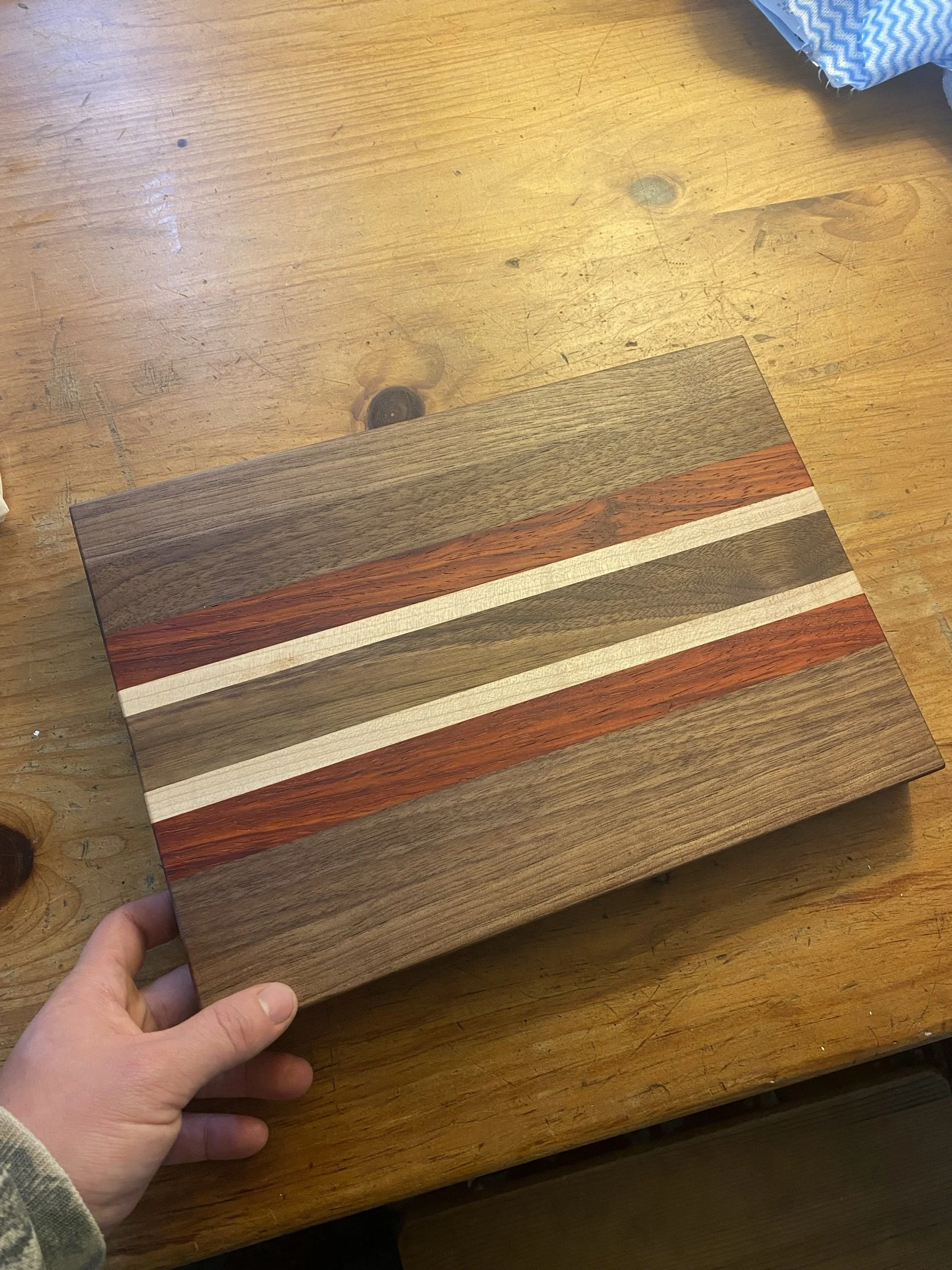 A striped hardwood serving board photographed indoors.