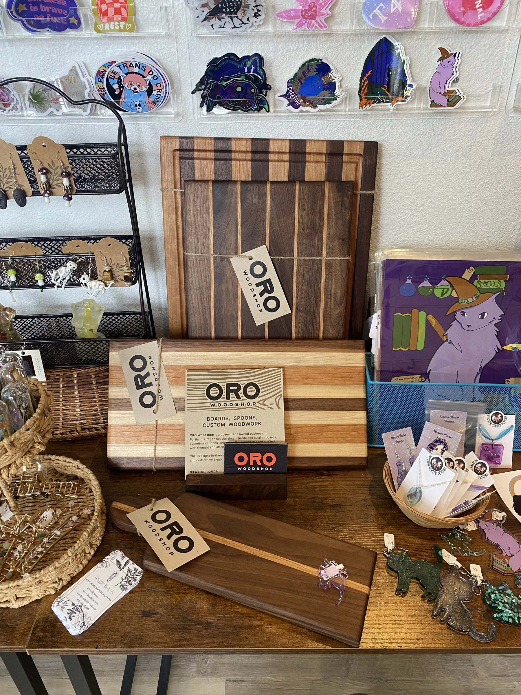 An Oro Woodshop market display of cutting boards with stickers.