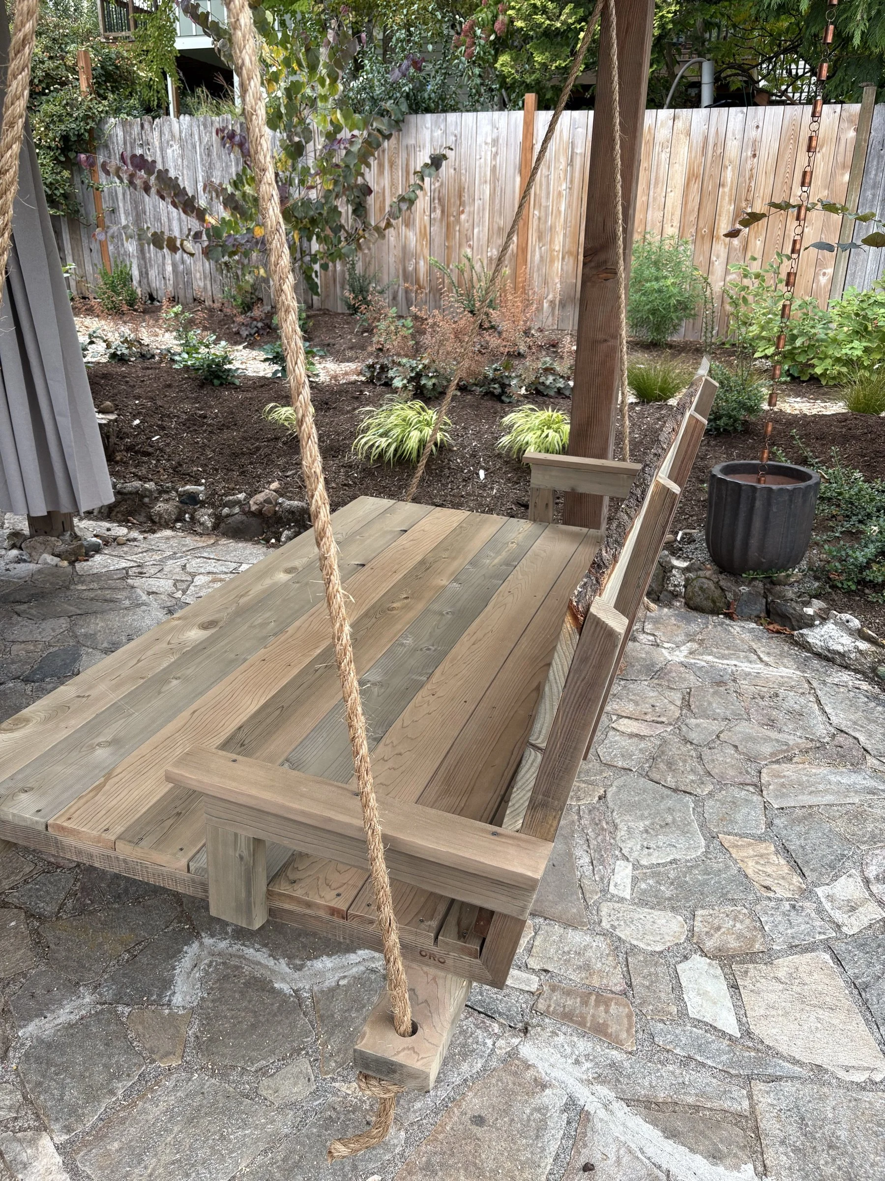 Angled view of the cedar daybed swing platform and hanging rope.