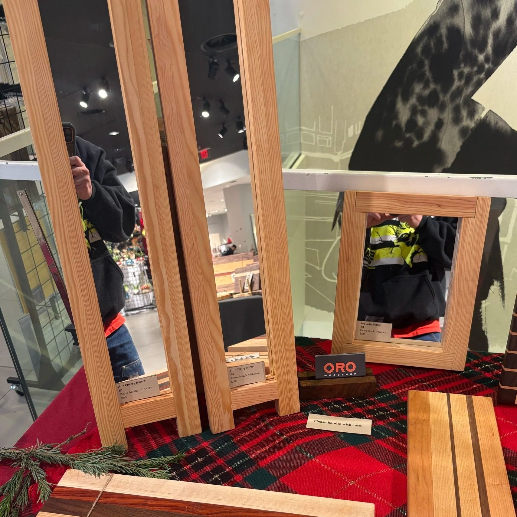 An Oro Woodshop craft-fair booth with mirrors and cutting boards.