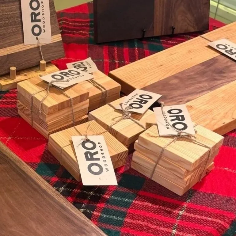 Oro Woodshop's market booth display of wooden coaster gift sets.