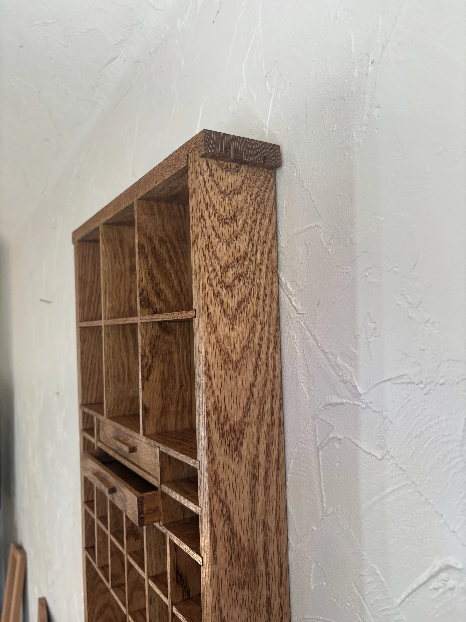 Detail of the oak curio shelf's mitered top corner and grain.