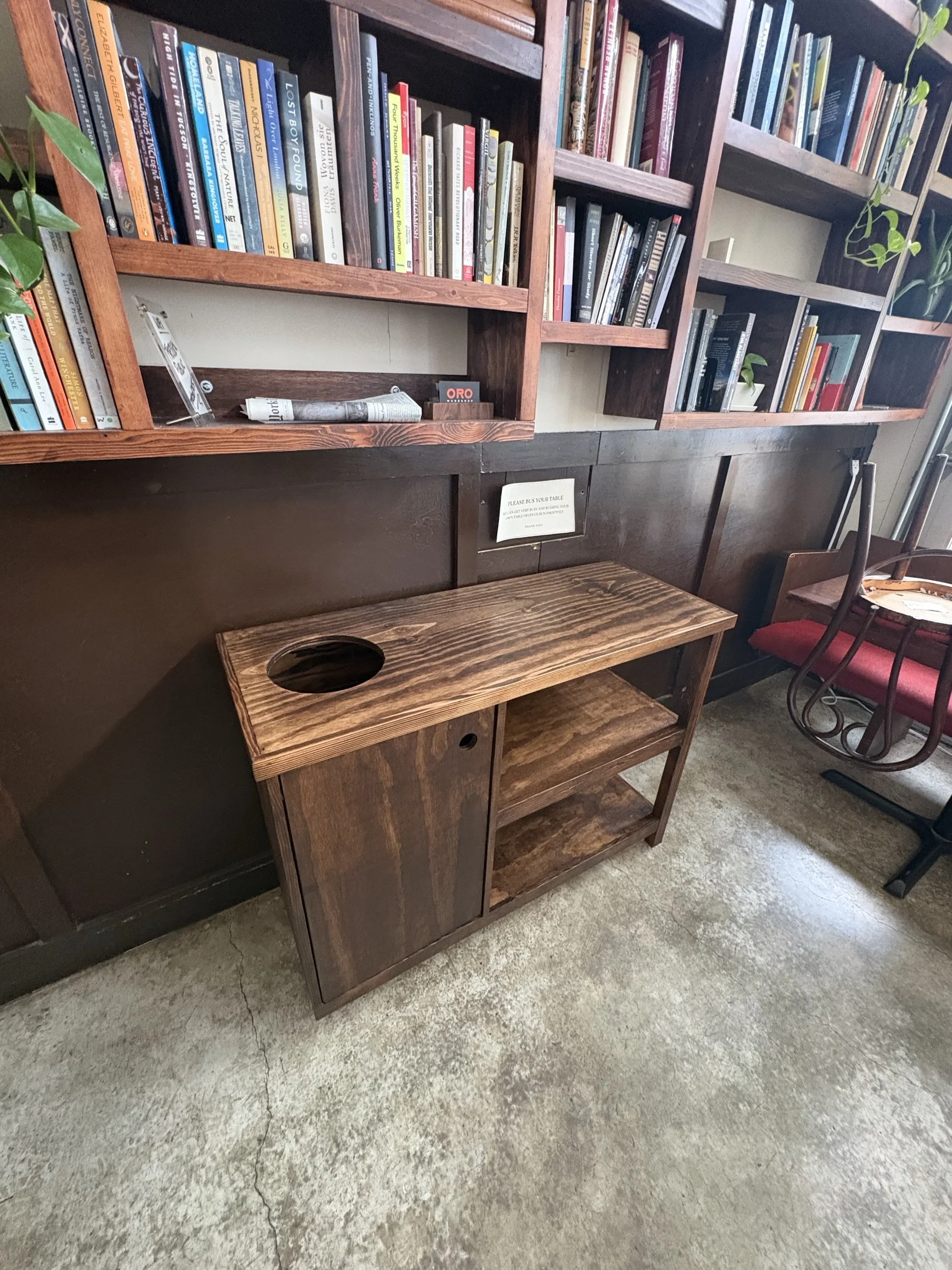 A stained fir bussing station with open shelves standing below the Fressen bookshelf.