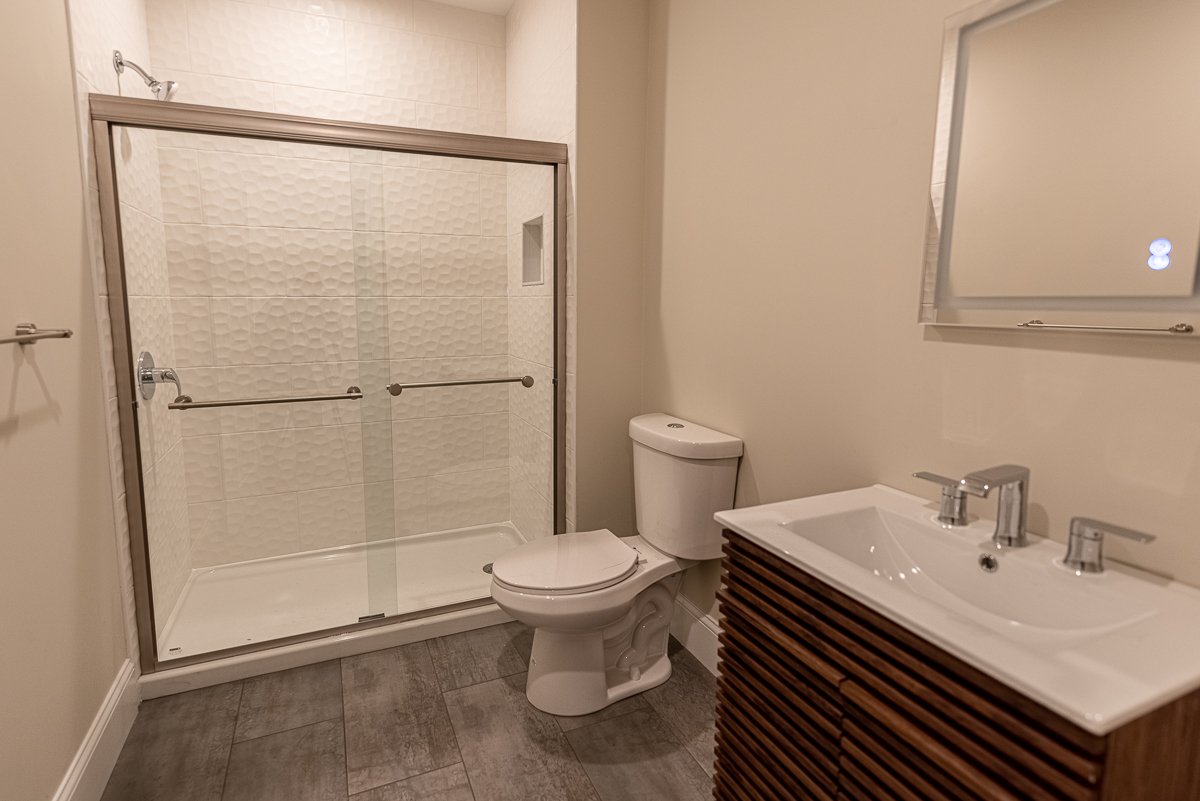 Bathroom with a shower stall, toilet, and a vanity with a sink.