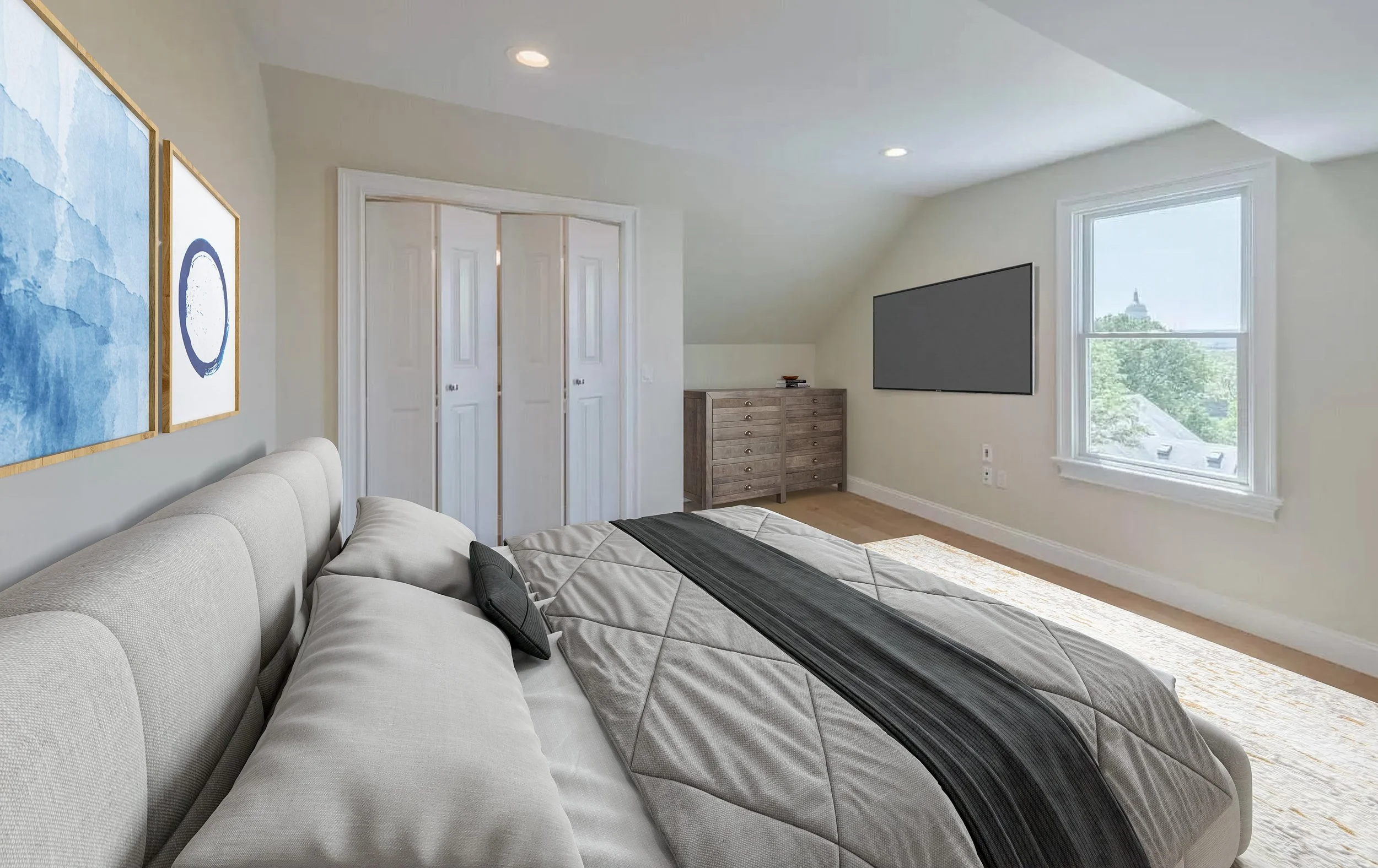 A bedroom with a large bed, artwork on the wall, a dresser, a mounted flat-screen TV, and a window with a view of trees and a building with a dome.