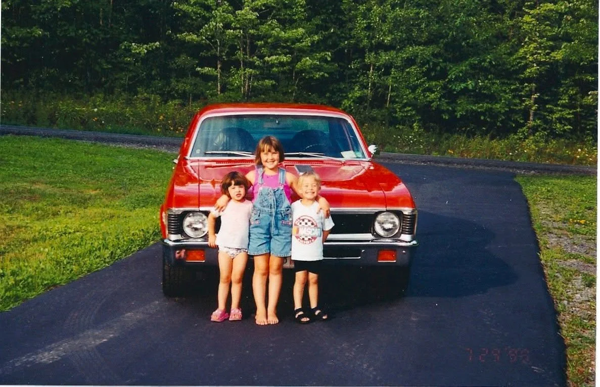 Upstate NY in Chemung County, '72 Nova in pumpkin orange with three little kids in front of it.