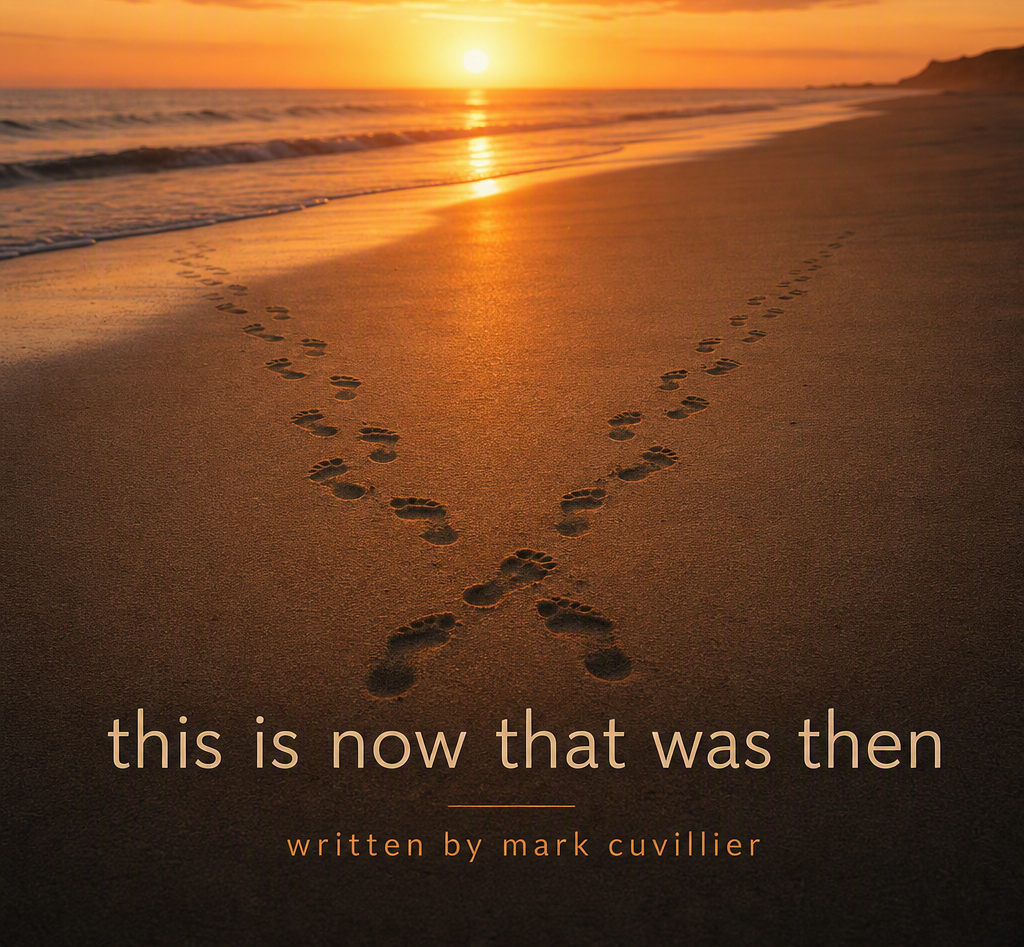 Footprints in the sand on a beach during sunset, with the ocean and distant cliffs visible in the background.