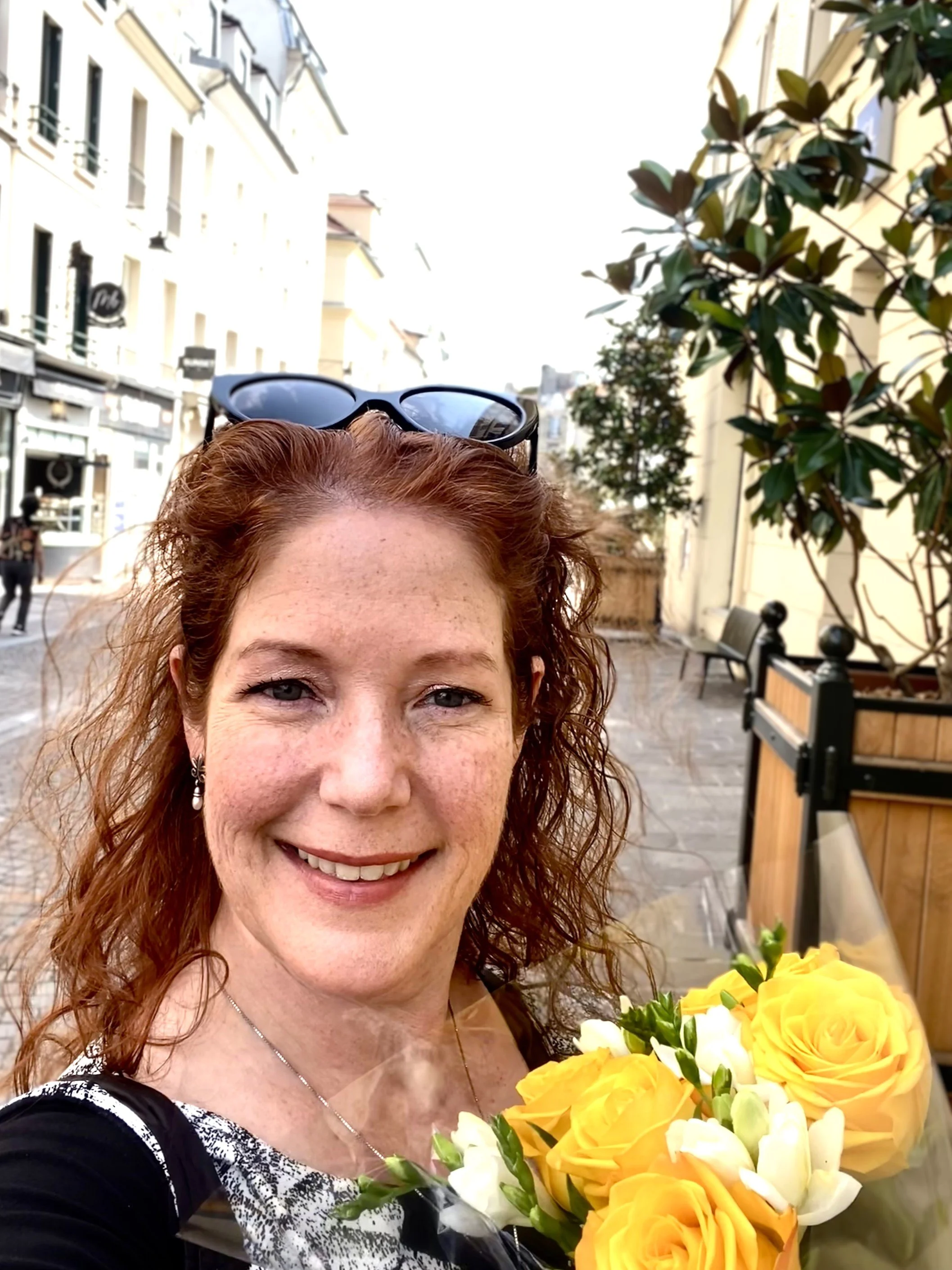 Amanda Bacqué holding flowers purchased for her Paris apartment in Saint-Germain-en-Laye France August 2025.