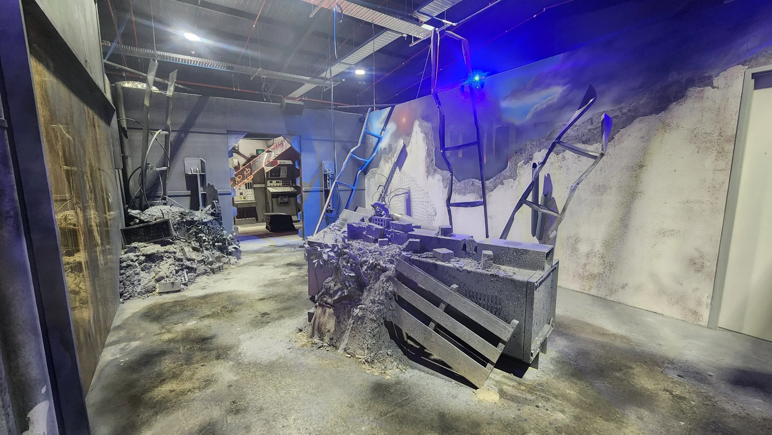 Interior scene showing destruction with rubble, broken structures, and debris scattered across the floor, possibly from an explosion or disaster in an indoor area.