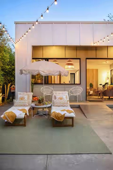 Sun beds, umbrella, cottage, festoon lighting, greenery