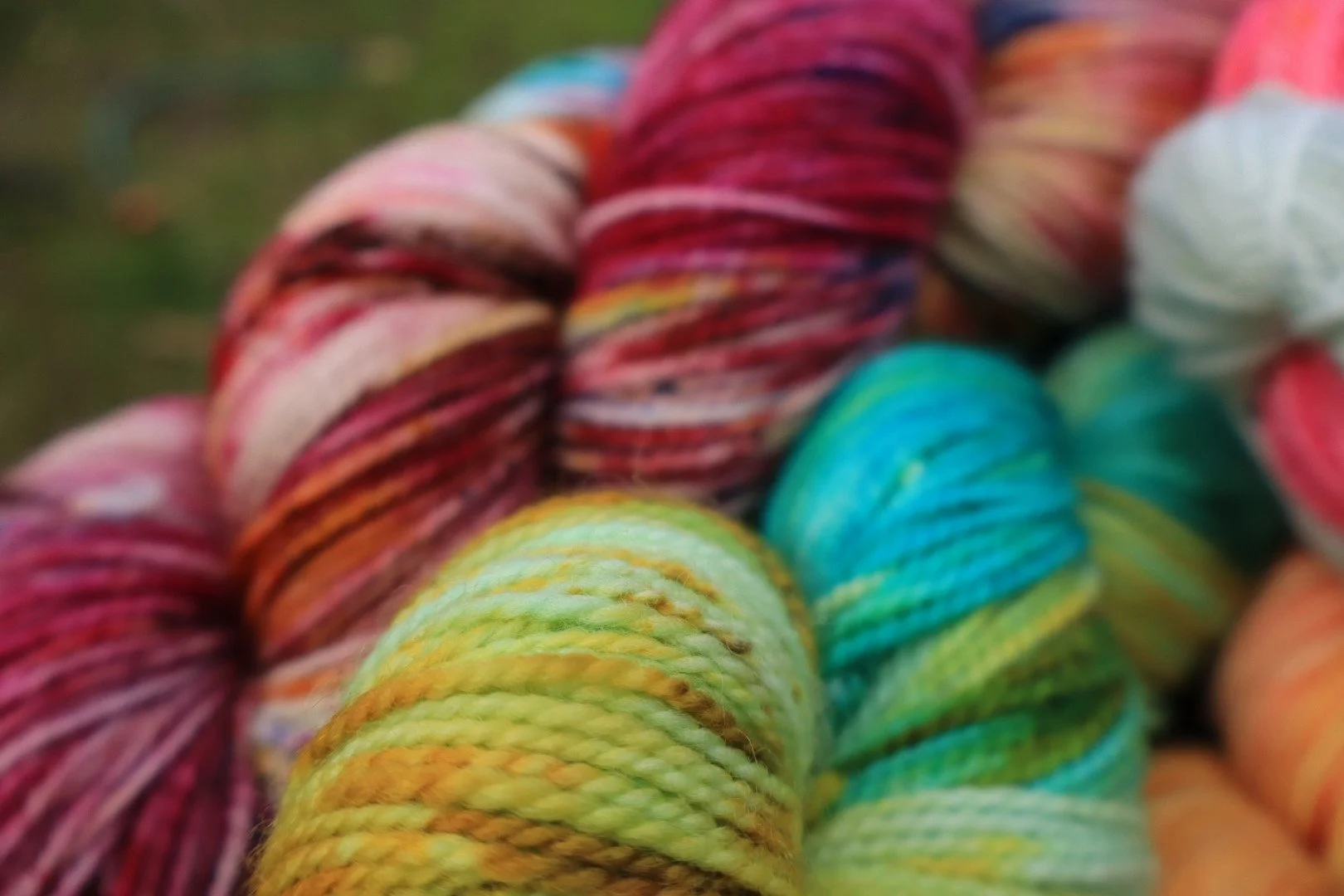 Close-up of colorful skeins of yarn in shades of pink, red, yellow, green, blue, and white.