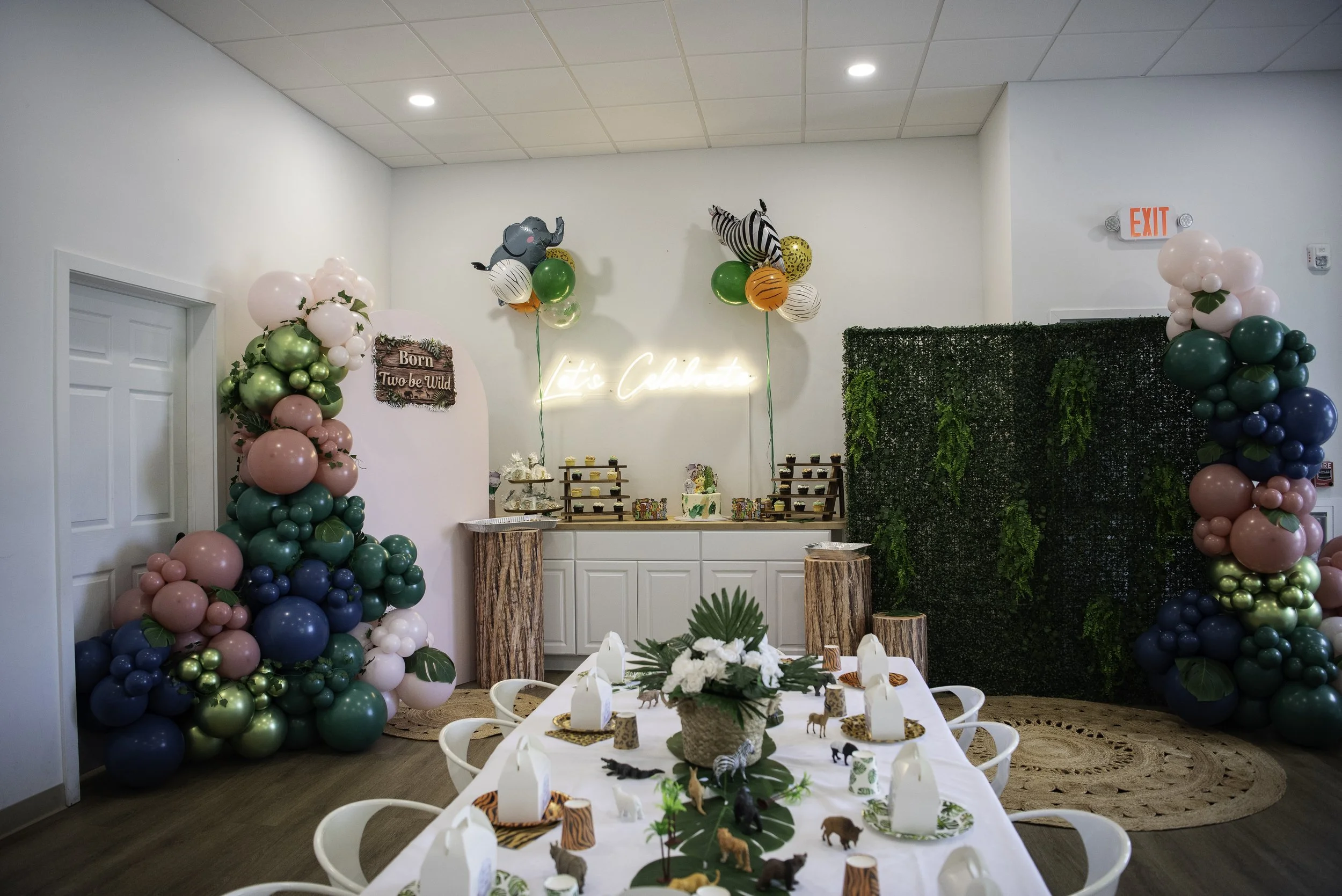 Colorful event space decorated with balloons, greenery, and elegantly set tables.