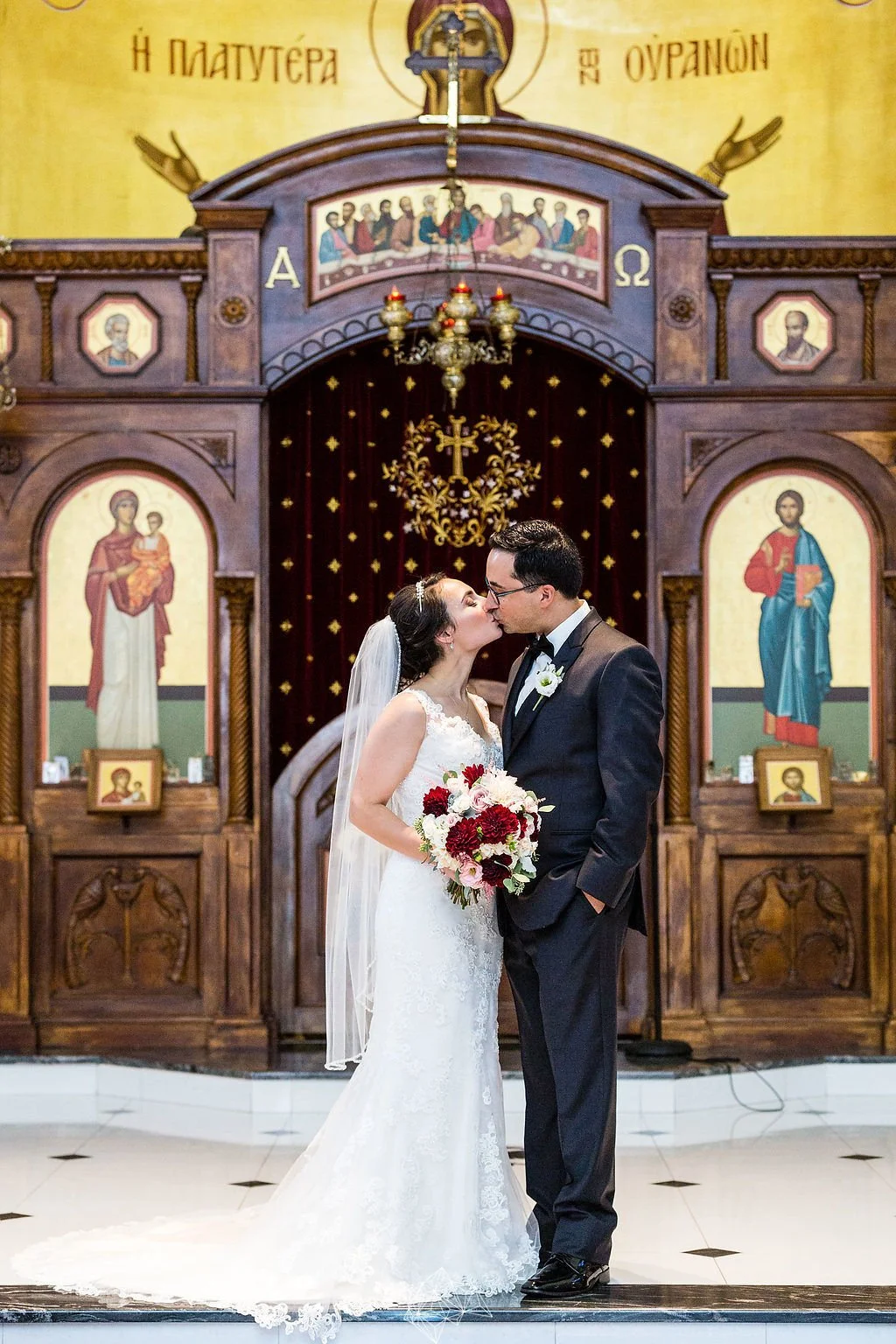 Bride and groom kissing inside a church after their wedding ceremony.