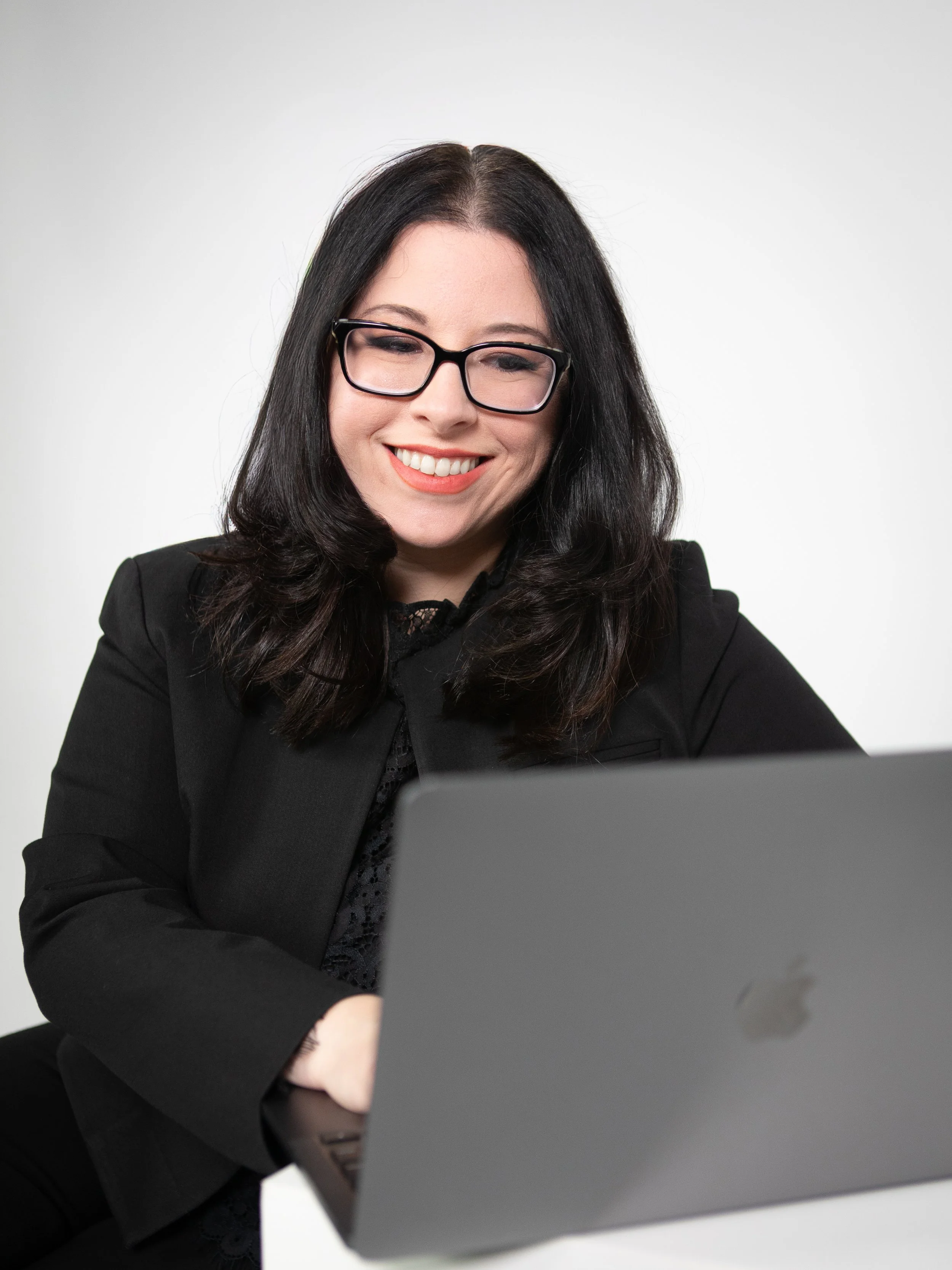 Kiersten, the creative director, smiling while working on a laptop.