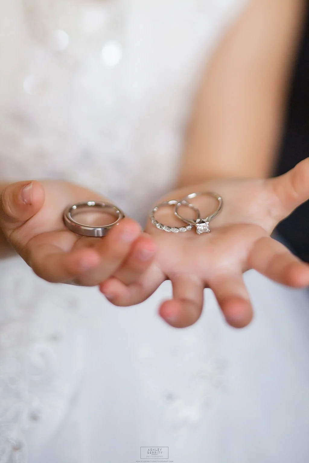 Bride holding her wedding and engagement rings in the palms of her hands.
