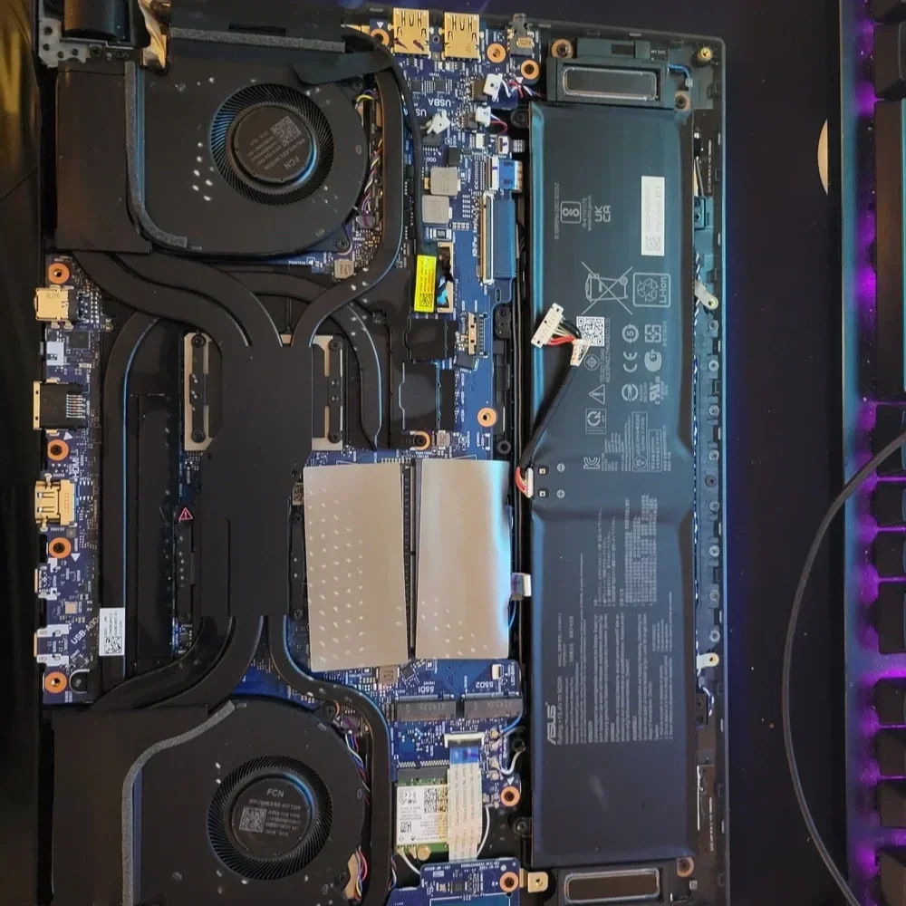 The interior of a desktop computer with visible cooling fans, motherboard, and a large battery pack, possibly for a gaming or high-performance PC.