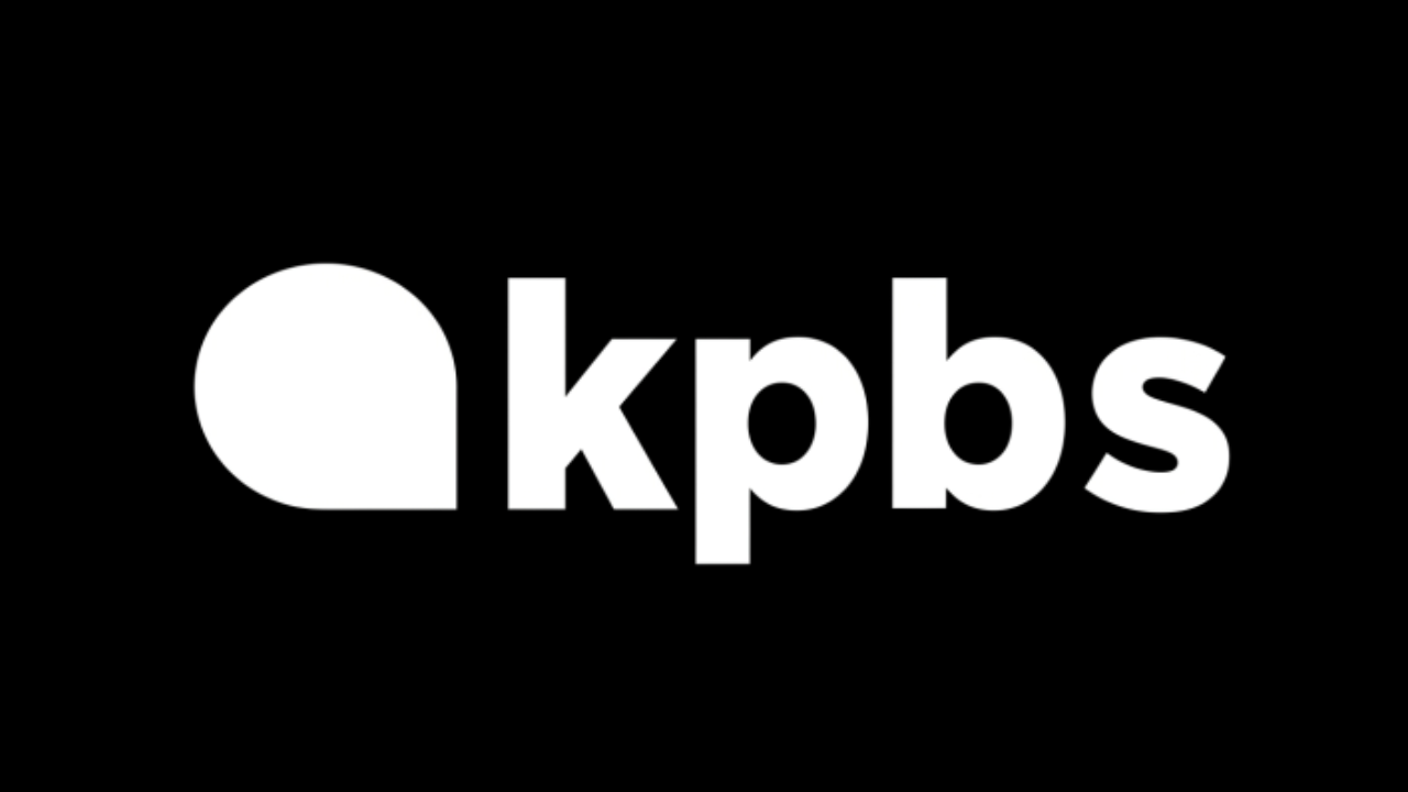 Logo of KPBS, a public broadcasting station, featuring a white speech bubble icon and the text 'kpbs' in lowercase letters on a black background.