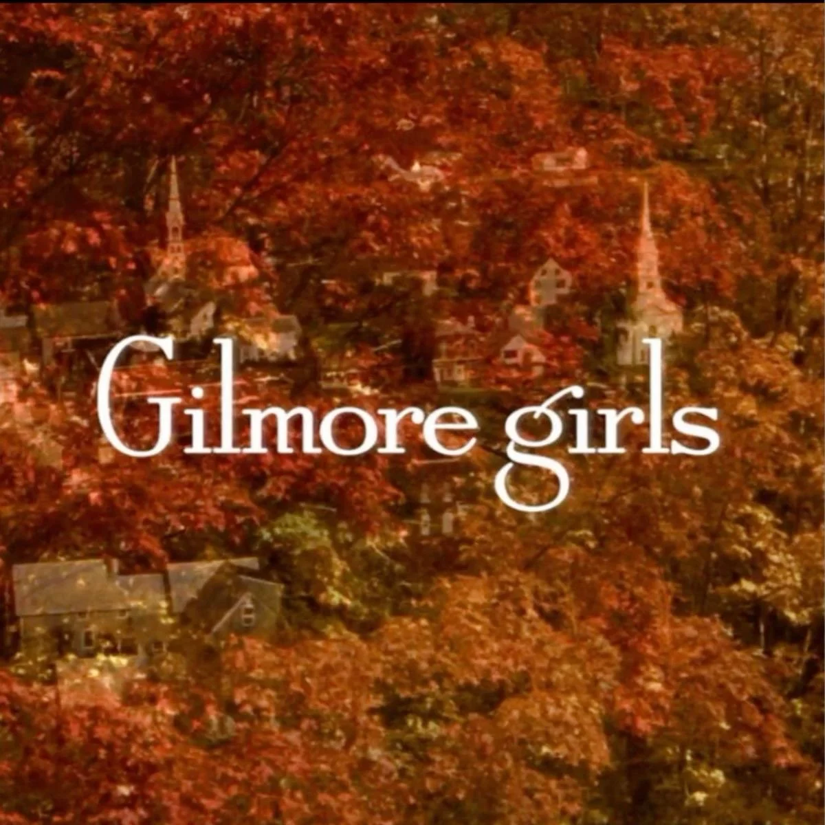 Autumn scene of a small town with trees in fall colors and church steeples, overlaid with the text 'Gilmore girls' in white font.