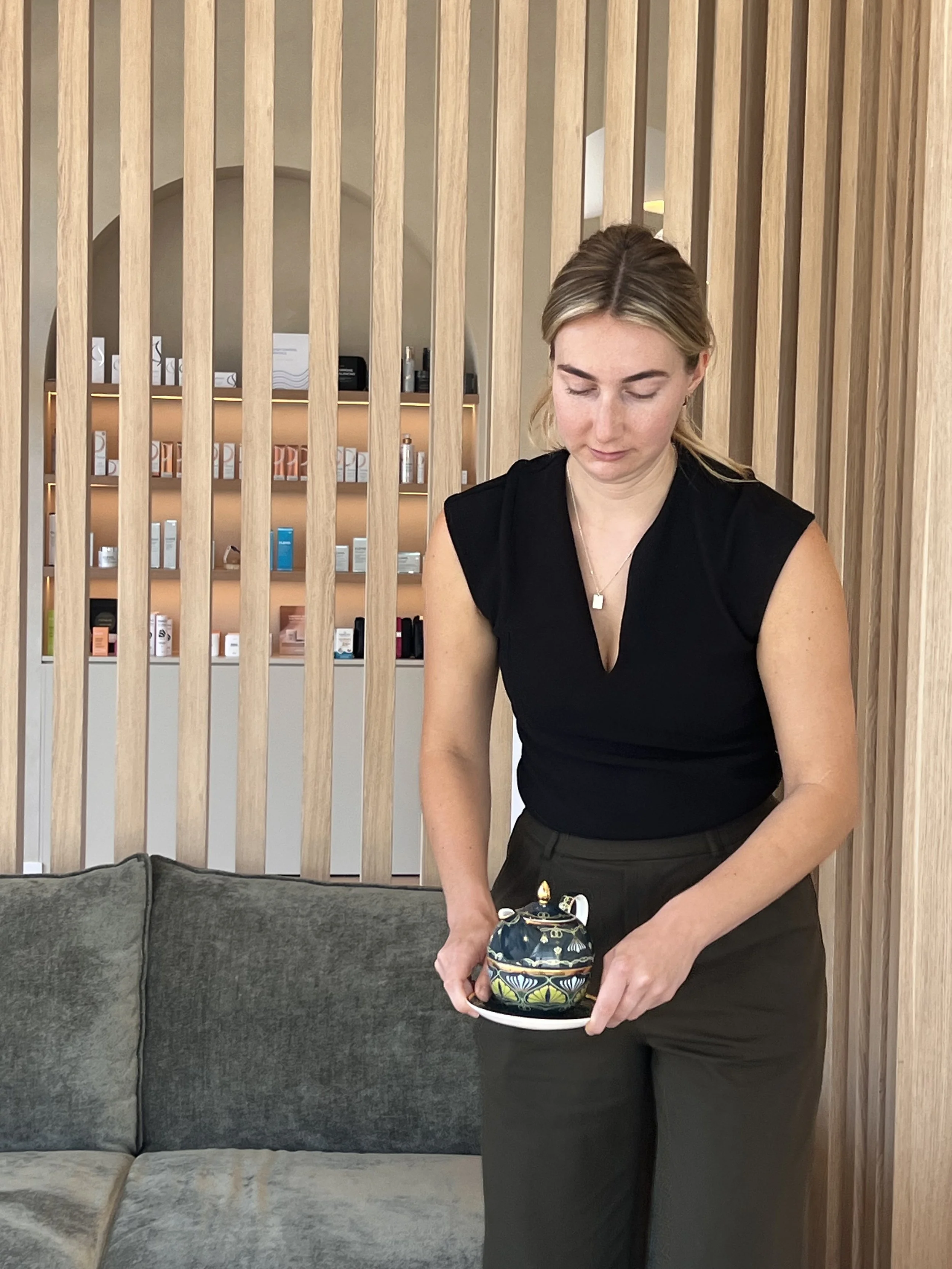 Therapist serving herbal tea after a Relax Massage at Queenstown Massage inside Indulge Skin & Wellness.