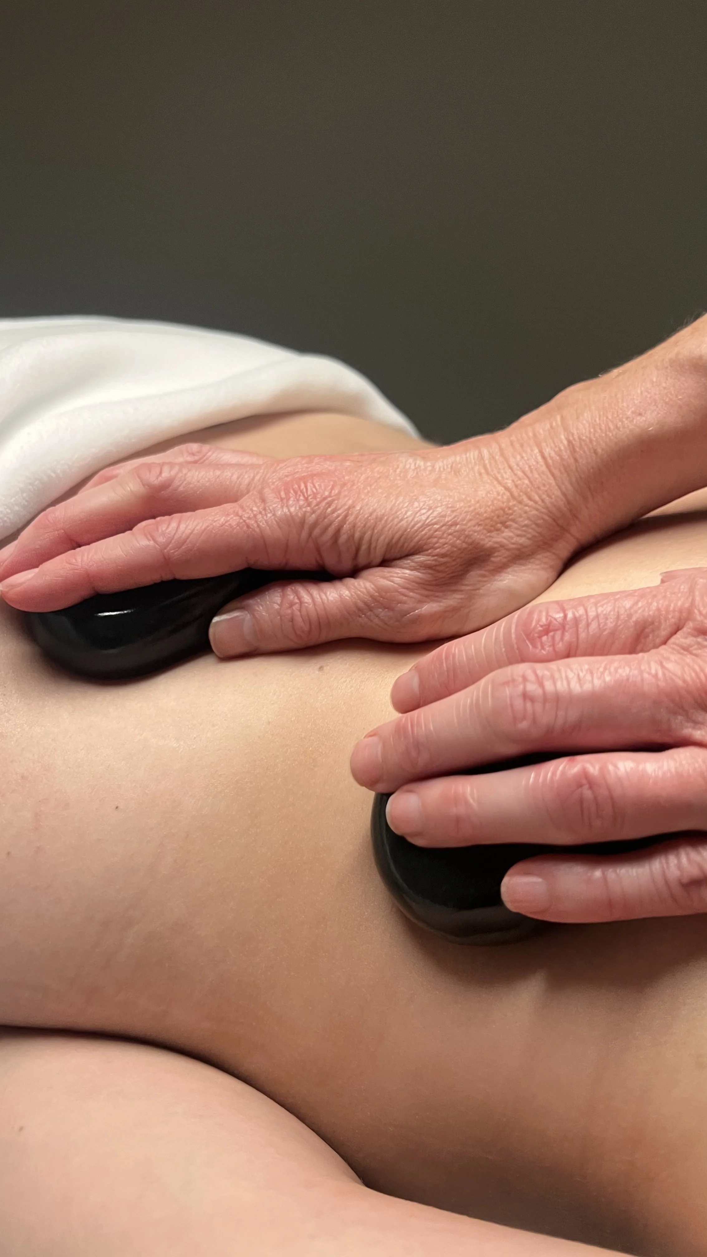 Hot stones used during a Recovery Massage to ease muscle tension at Queenstown Massage in Frankton.