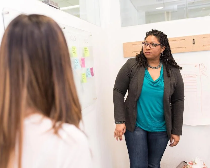 An executive standing next to a dry erase board