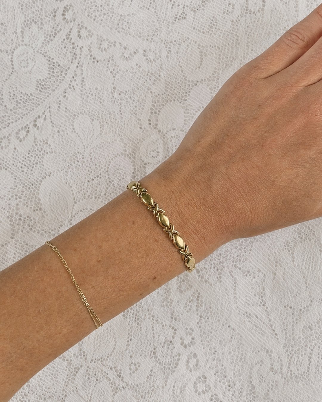 Close-up of a model wearing the solid gold chain bracelet on her wrist
