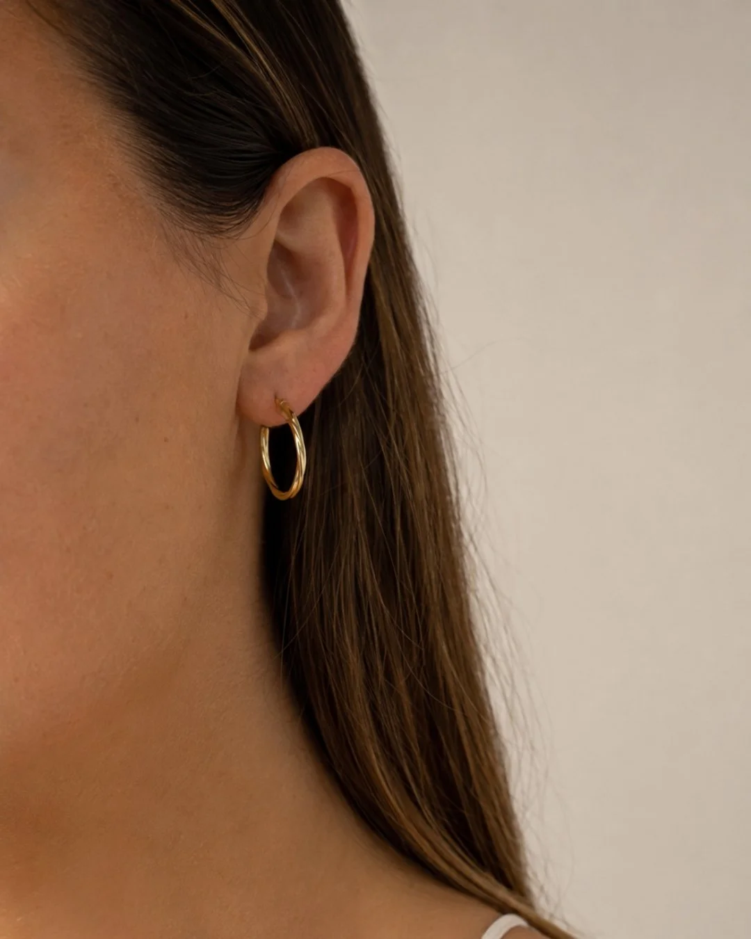 Close-up of a model wearing a vintage gold hoop earring, a pre-loved piece from Vallora Vintage.