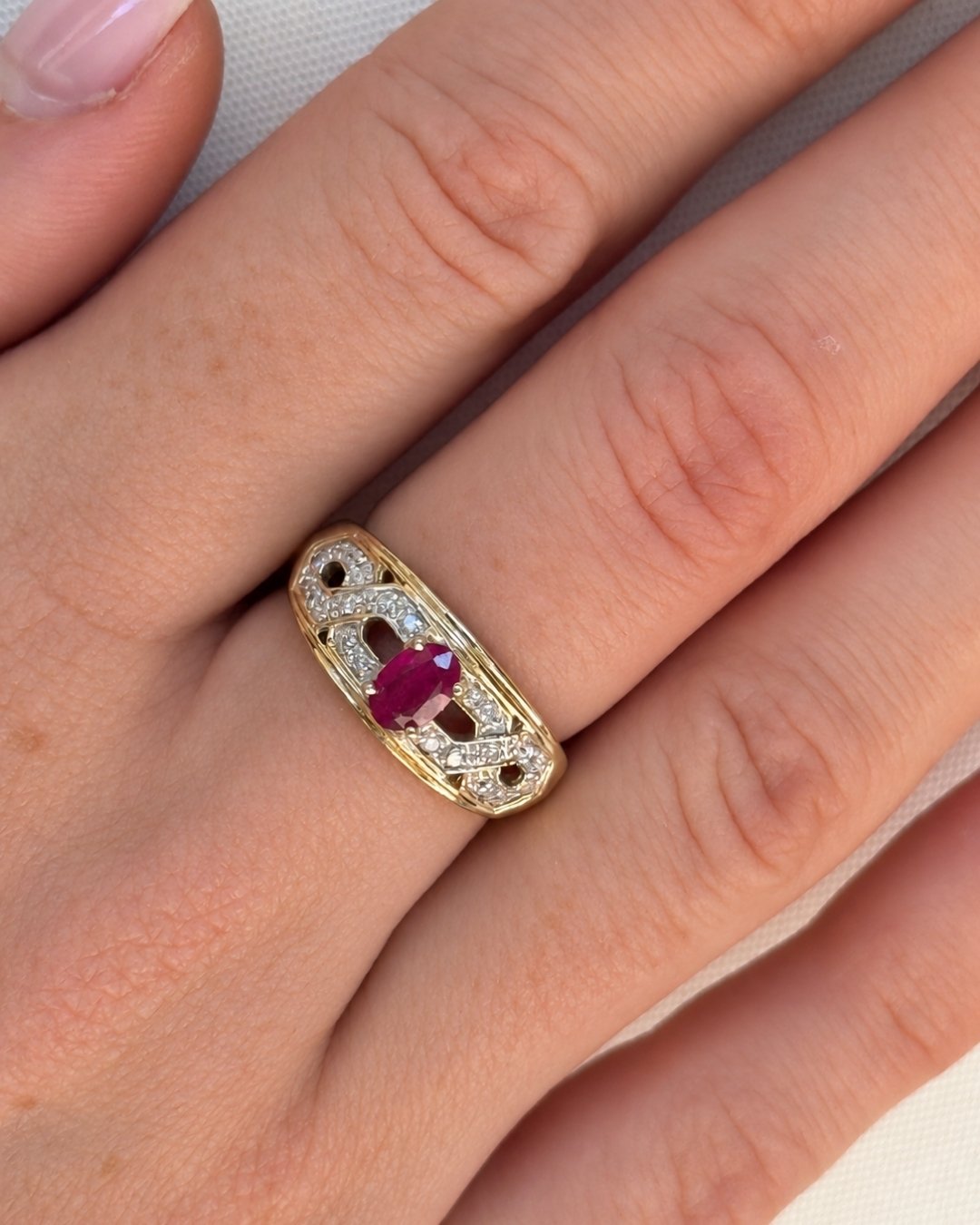 Woman wearing a vintage 10ct gold ruby and diamond ring on her finger - Vallora Vintage