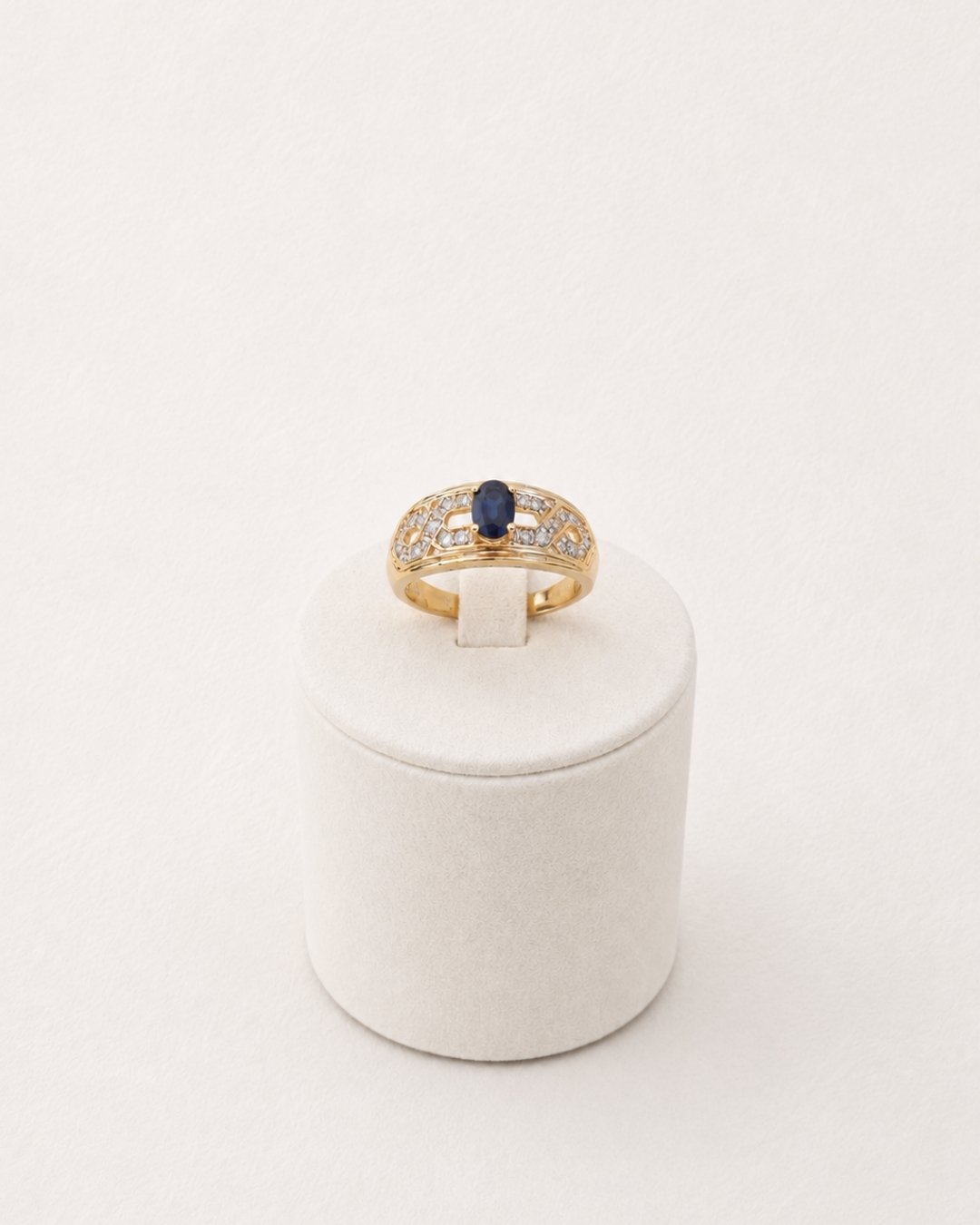 Close-up side view of vintage 10ct gold ring with sapphire and diamond scrollwork setting - Vallora Vintage