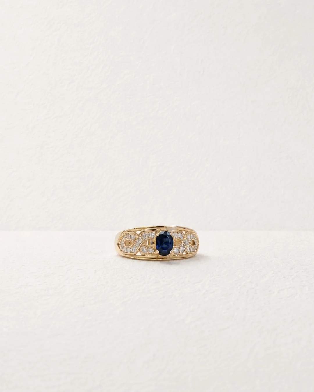 Close-up of hand wearing a vintage 10ct gold sapphire and diamond ring - Vallora Vintage