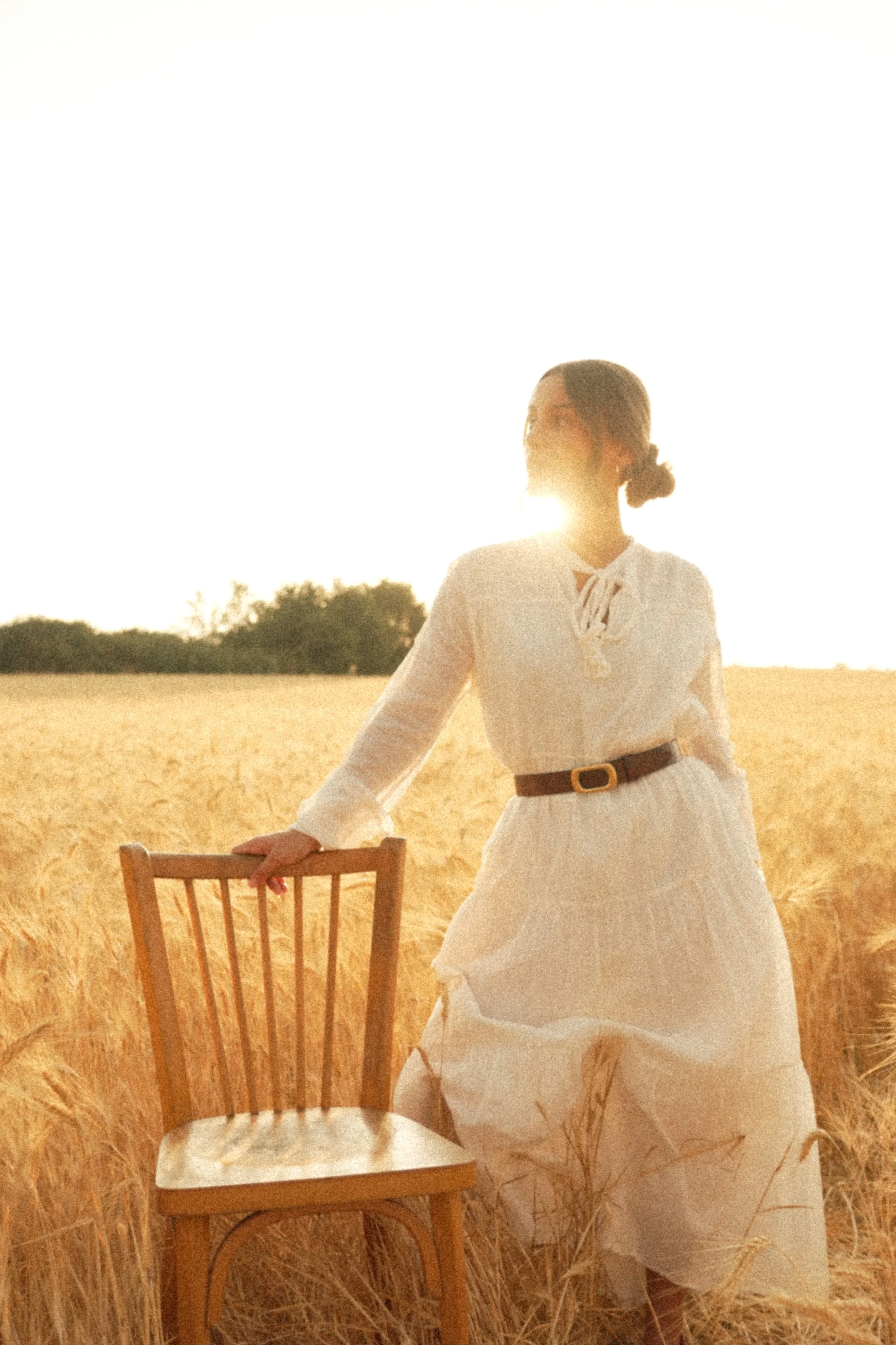 Une femme en robe blanche porte une ceinture Adèle Atelier Nappa