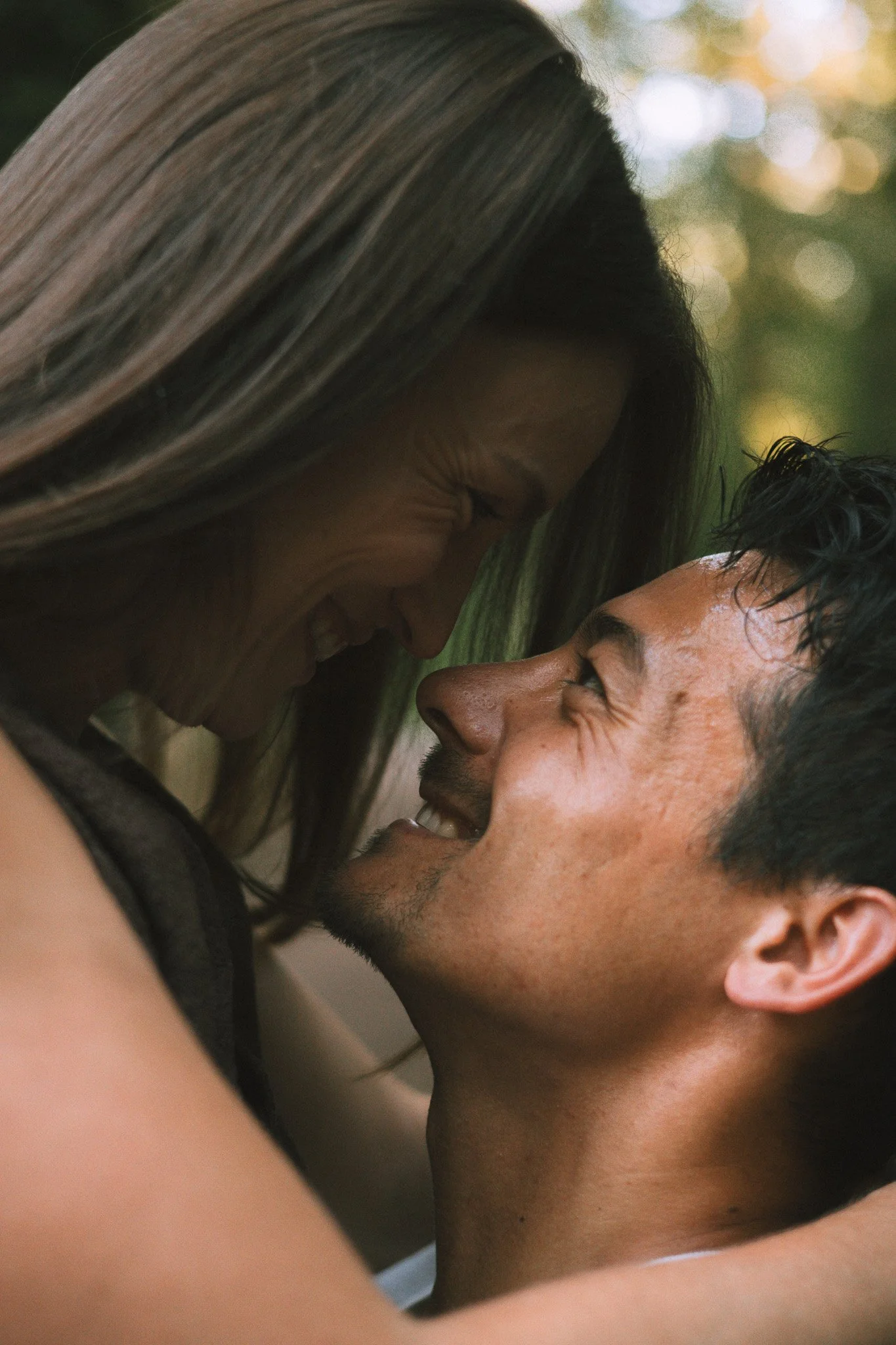 Un homme et une femme sont très proches, souriant et ayant un moment intime, leur visage est très proche l'un de l'autre.