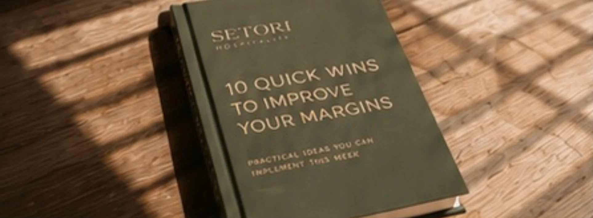 Book titled '10 Quick Wins to Improve Your Margins' by SeTori, placed on a wooden surface with shadow patterns.