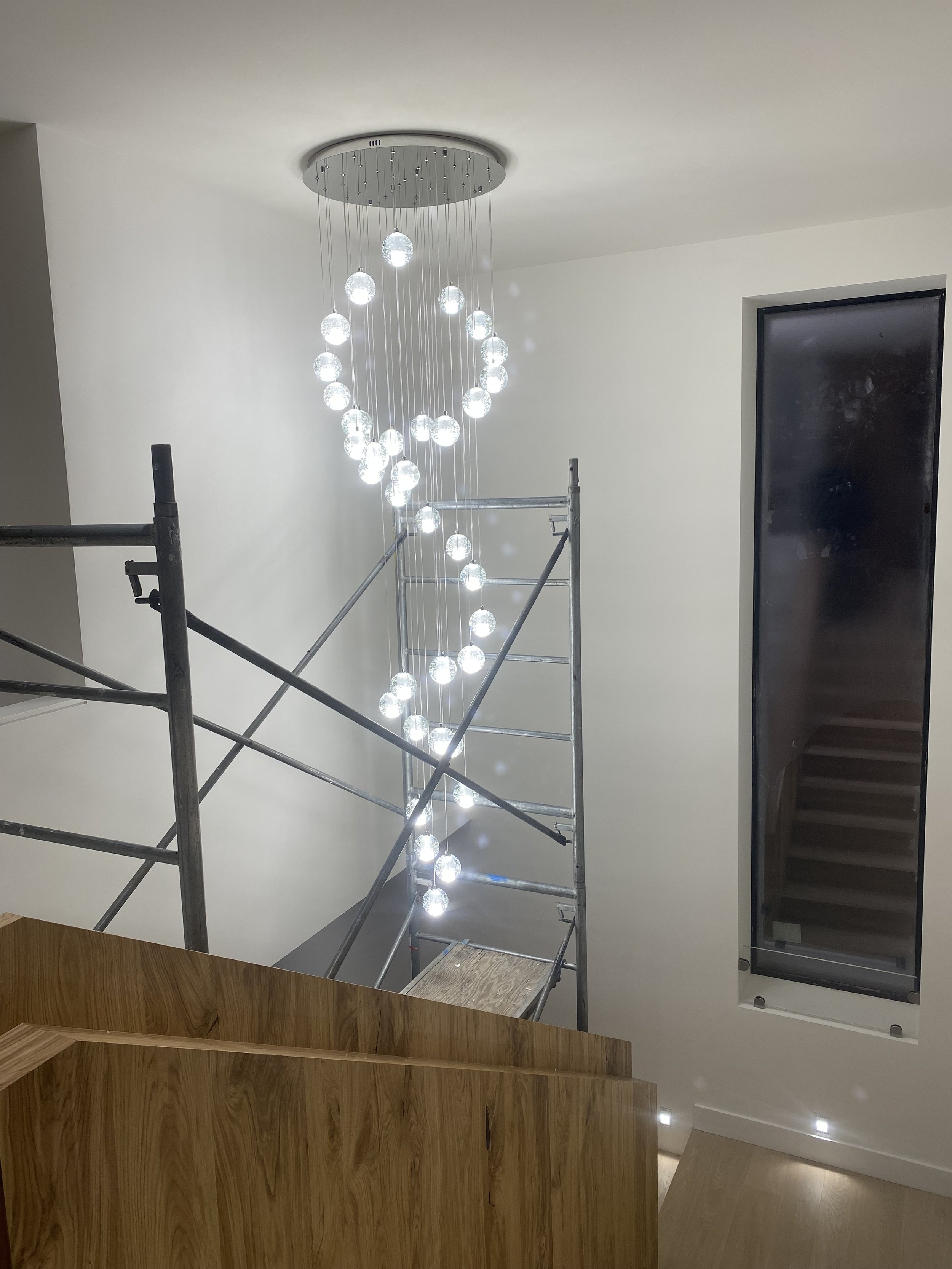 Multi-pendant stairwell chandelier installed by Canberra Electric Co