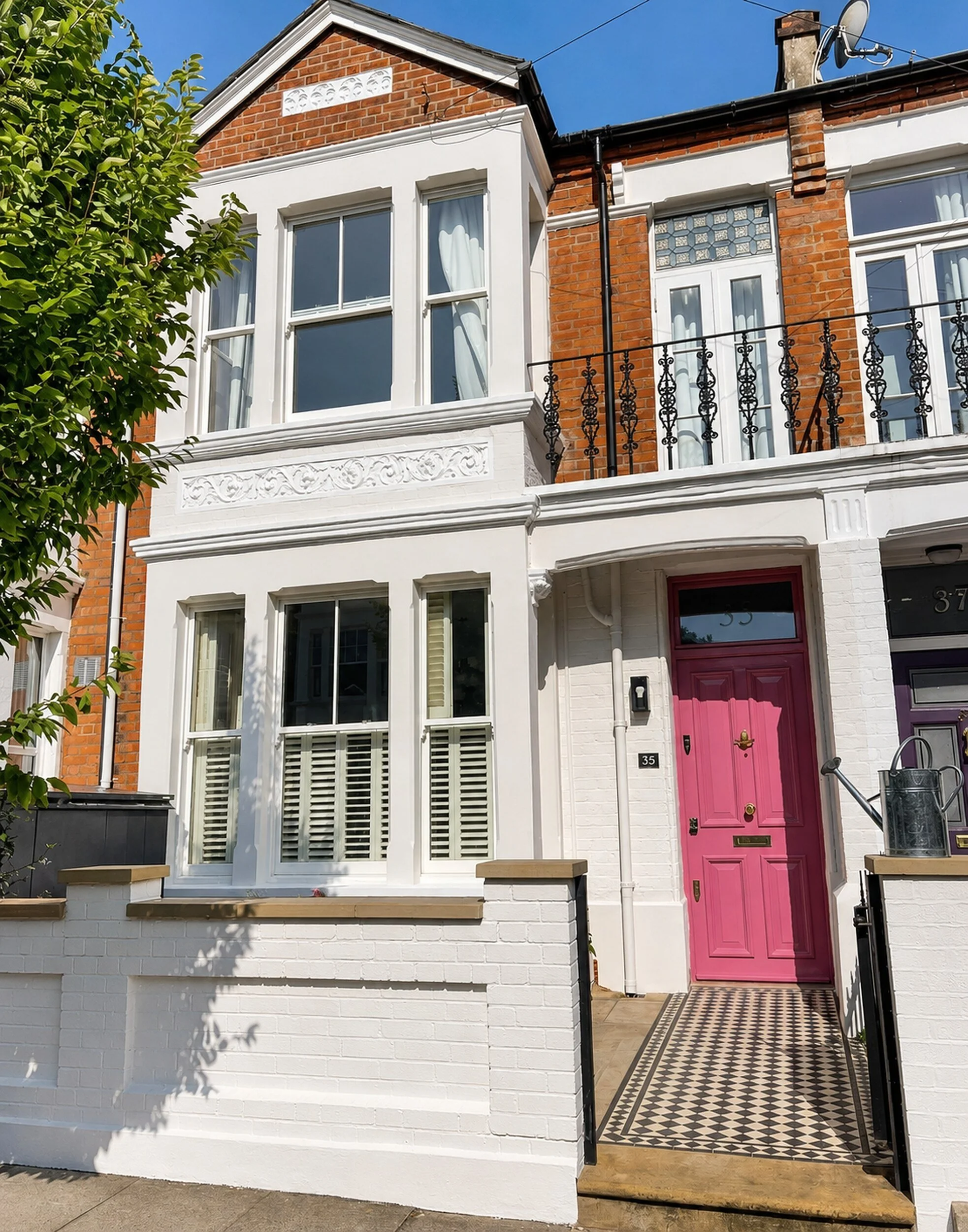 Terraced house exterior painted in two complementary whites, with minor masonry repairs and a freshly painted front boundary wall.