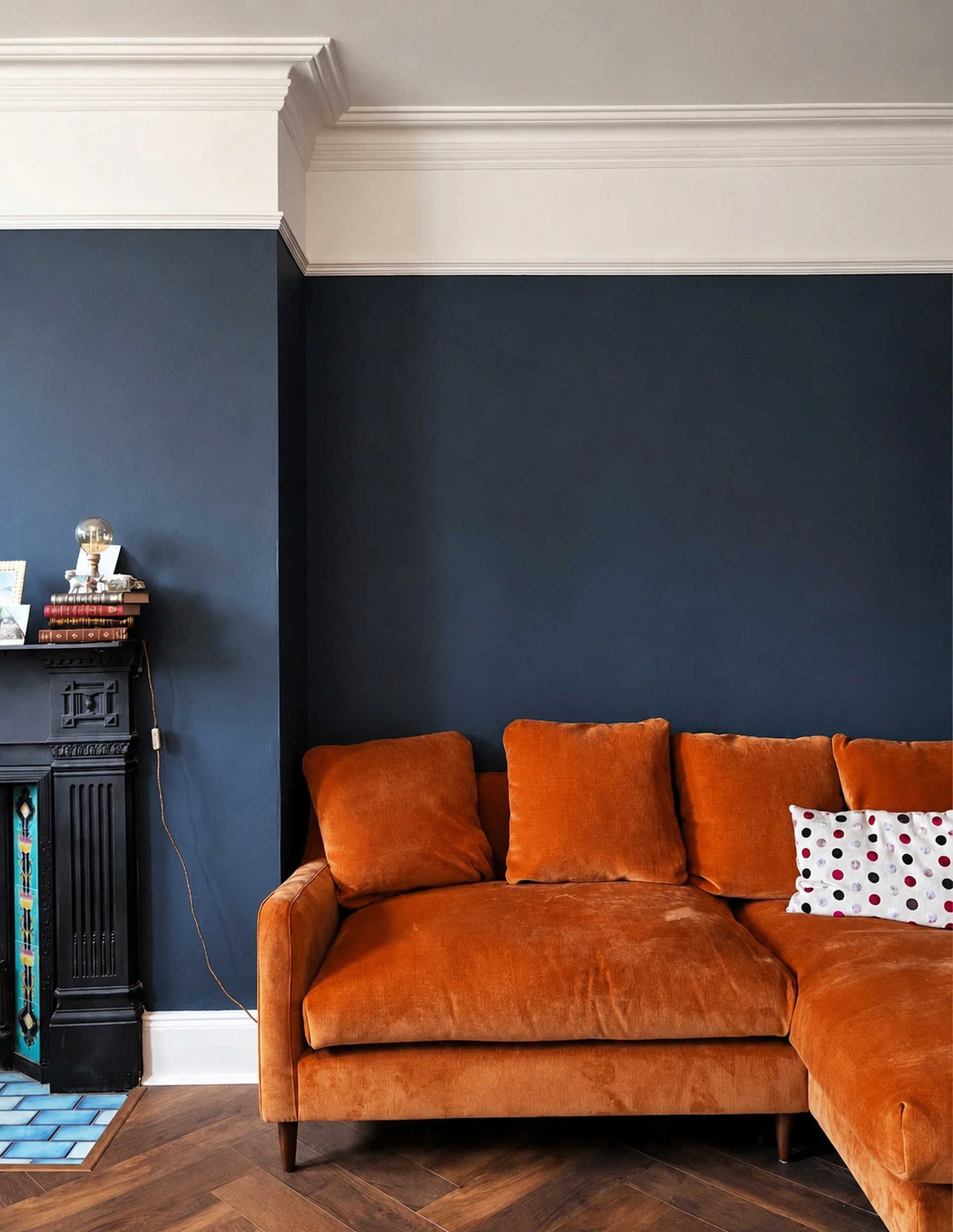 Living room walls painted in a rich royal blue, contrasting with the orange furnishings.