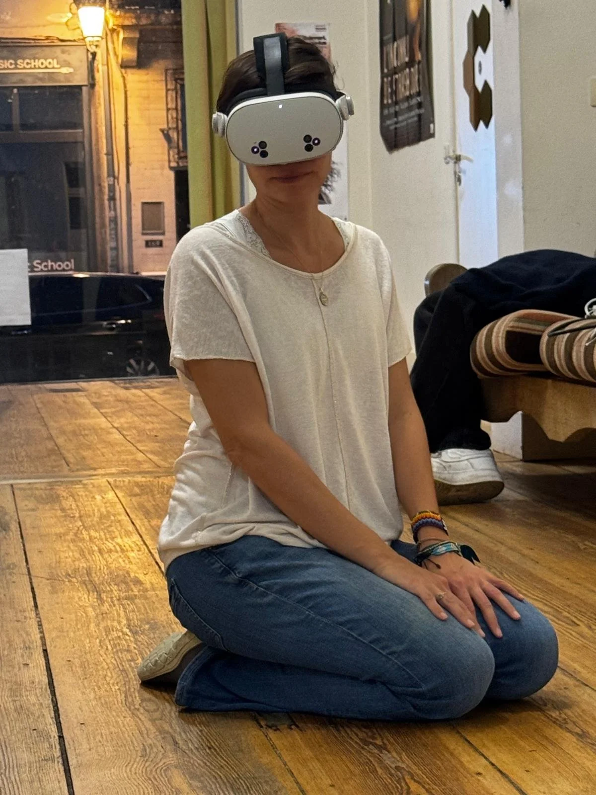 Une femme portant un casque de réalité virtuelle est agenouillée sur un sol en bois dans un intérieur accueillant, avec une atmosphère chaleureuse 