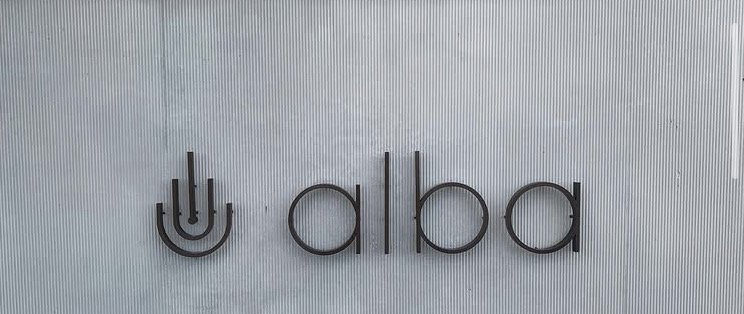 Close-up of a sign with the symbol for 'u' and the word 'aba' on a textured background.