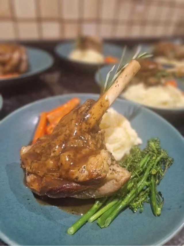Lamb shank served with mashed potatoes, broccoli, and carrot.