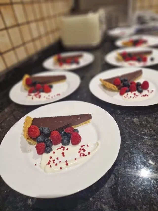 Slices of chocolate tart topped with mixed berries 