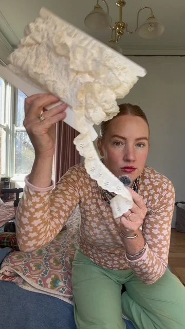A woman leaning forward showing a real of vintage material