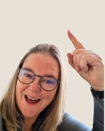 Inge van Wepzz wijst omhoog en lacht.