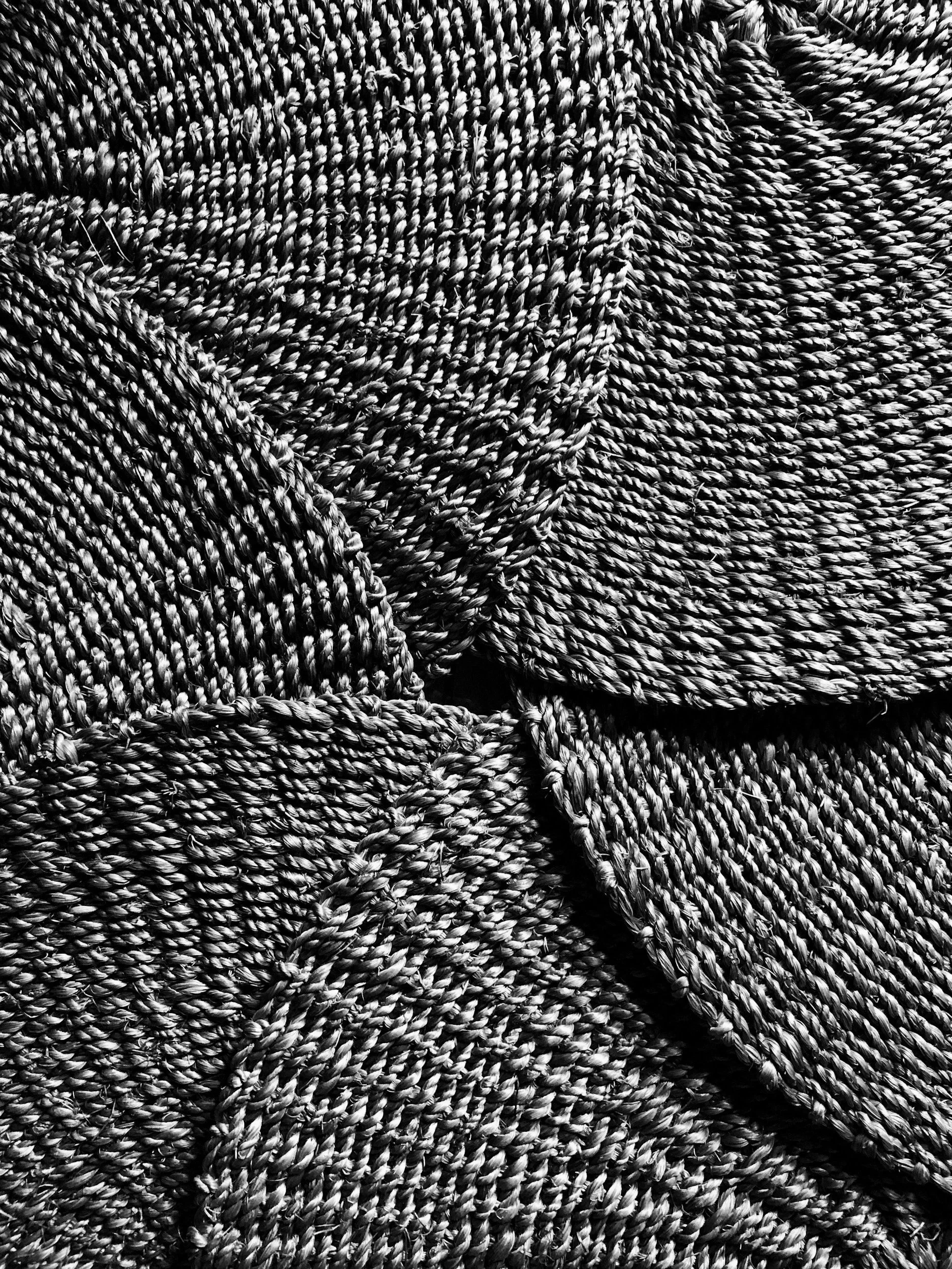 Close-up of woven fabric with twisted, braided threads in black and white.